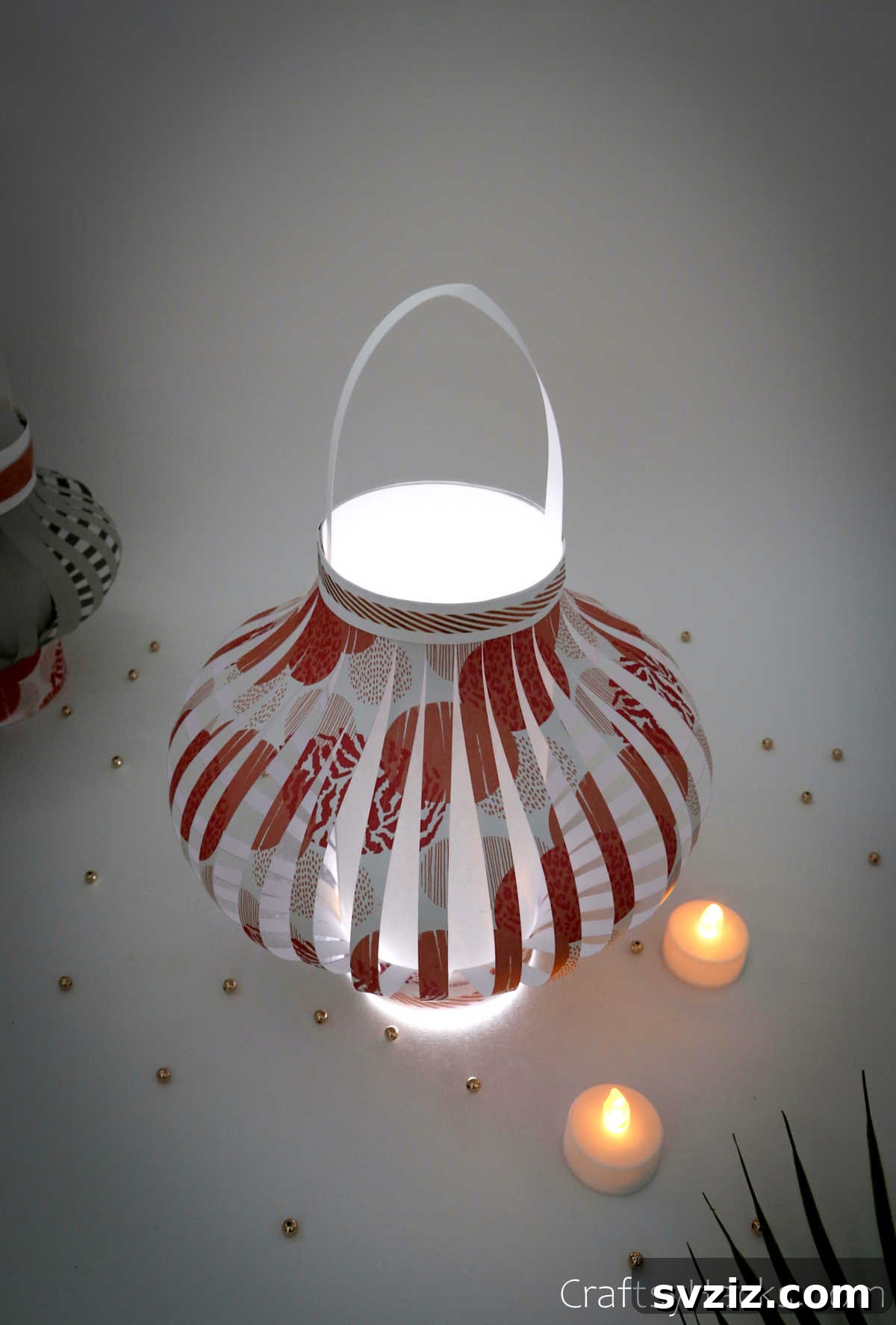 Craft Your Own Stunning Paper Lanterns 3 Two beautifully lit paper lanterns, one with intricate patterns, providing soft, inviting light, ideal for affordable home decoration.
