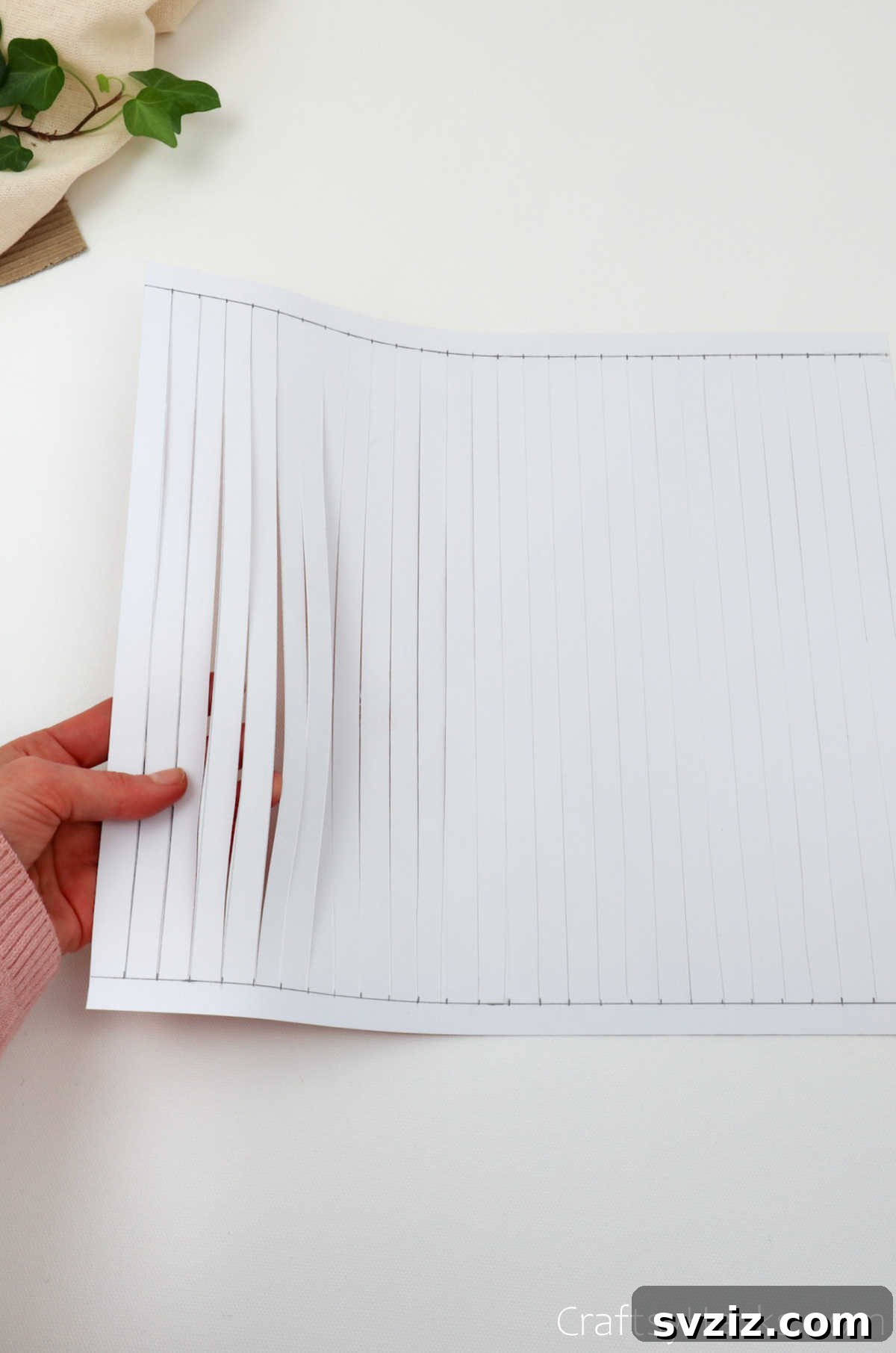 Craft Your Own Stunning Paper Lanterns 10 The craft paper is now fully cut into a series of vertical strips, maintaining connected bands at the top and bottom.
