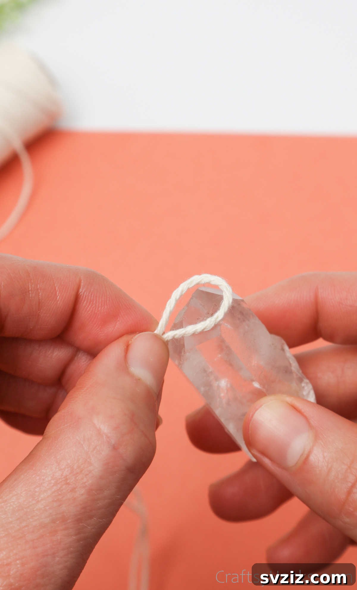 Simple Stone Necklace DIY Guide 11 Tightened loop of cotton twine around the base of a crystal, preparing for the first knot