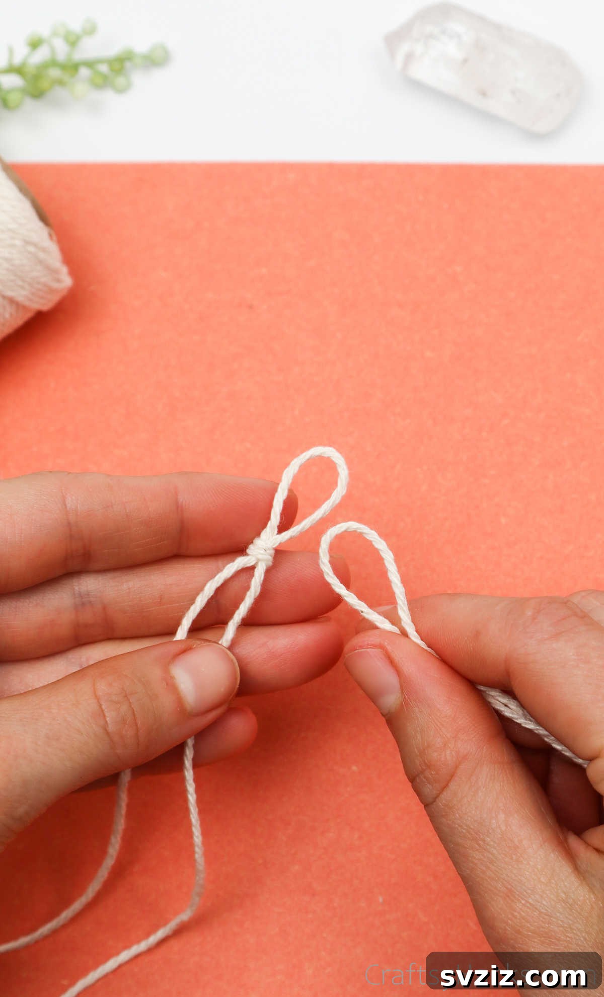 Simple Stone Necklace DIY Guide 15 The loop of the second cord being pulled through the loop of the first knot, showing two string loops connected