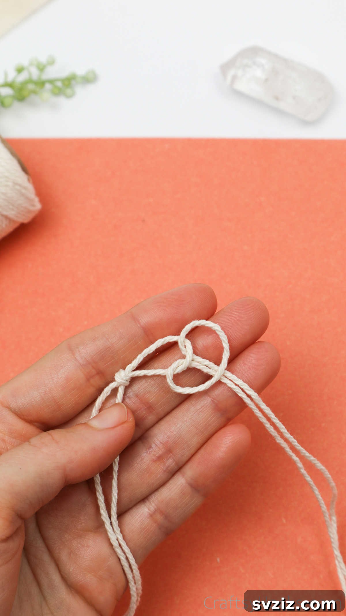 Simple Stone Necklace DIY Guide 17 The loose ends of the second cord being pulled through its own loop to create a knot