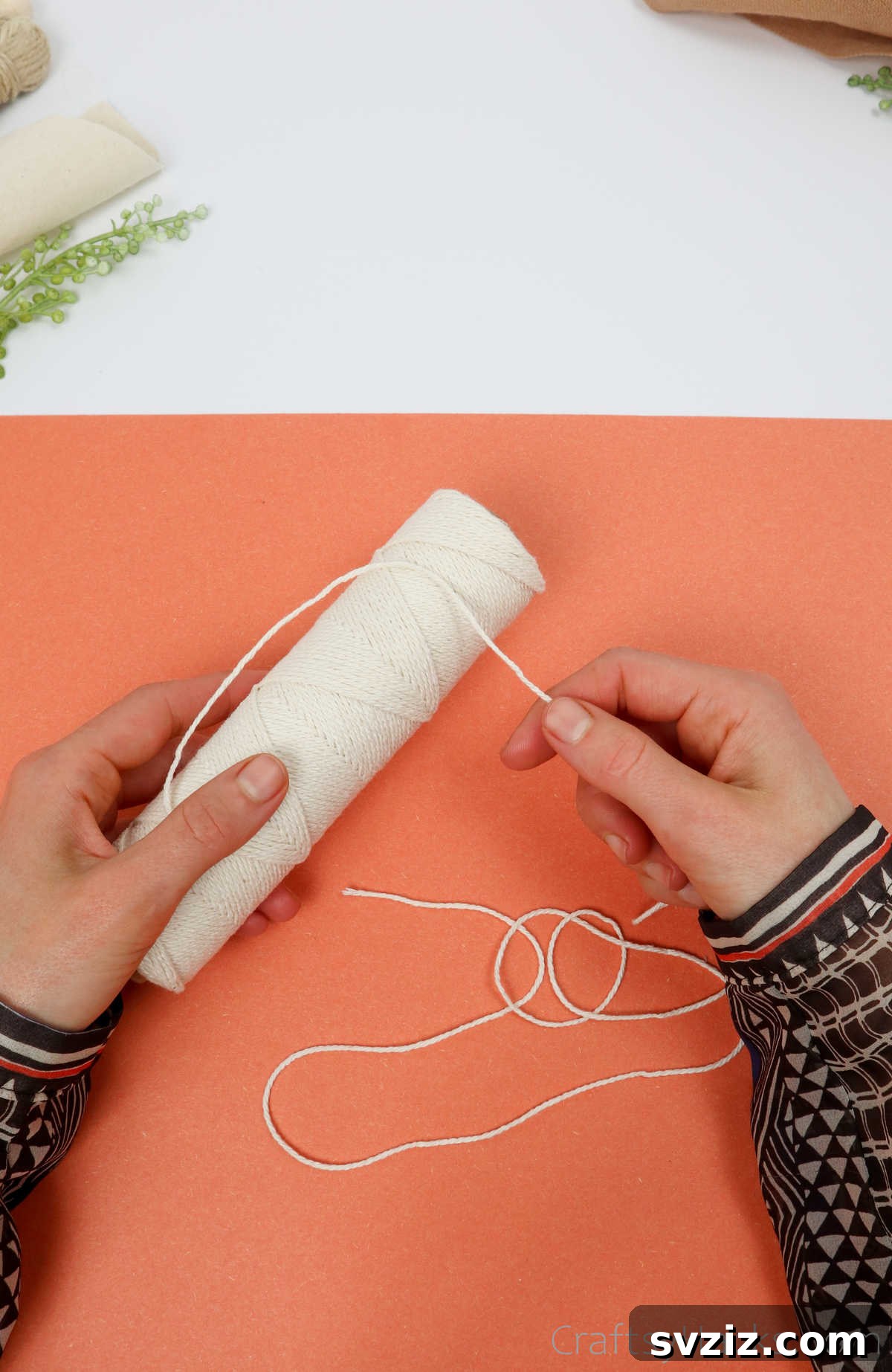 Simple Stone Necklace DIY Guide 6 Close-up of a hand holding a single, cut length of cotton twine, ready for crafting