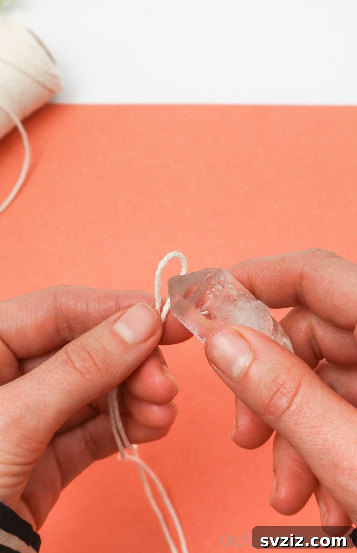 Simple Stone Necklace DIY Guide 10 A close-up view of a string loop securely positioned around the bottom of a crystal