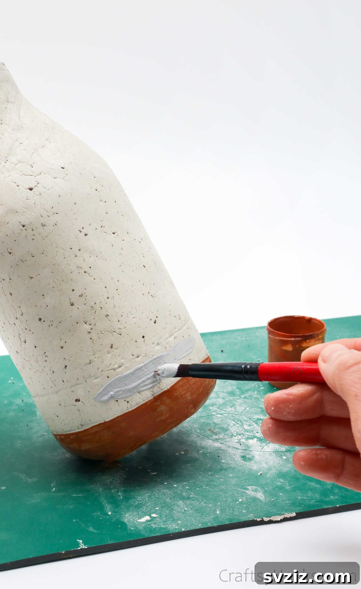 Painting a White Line Detail on Clay Vase