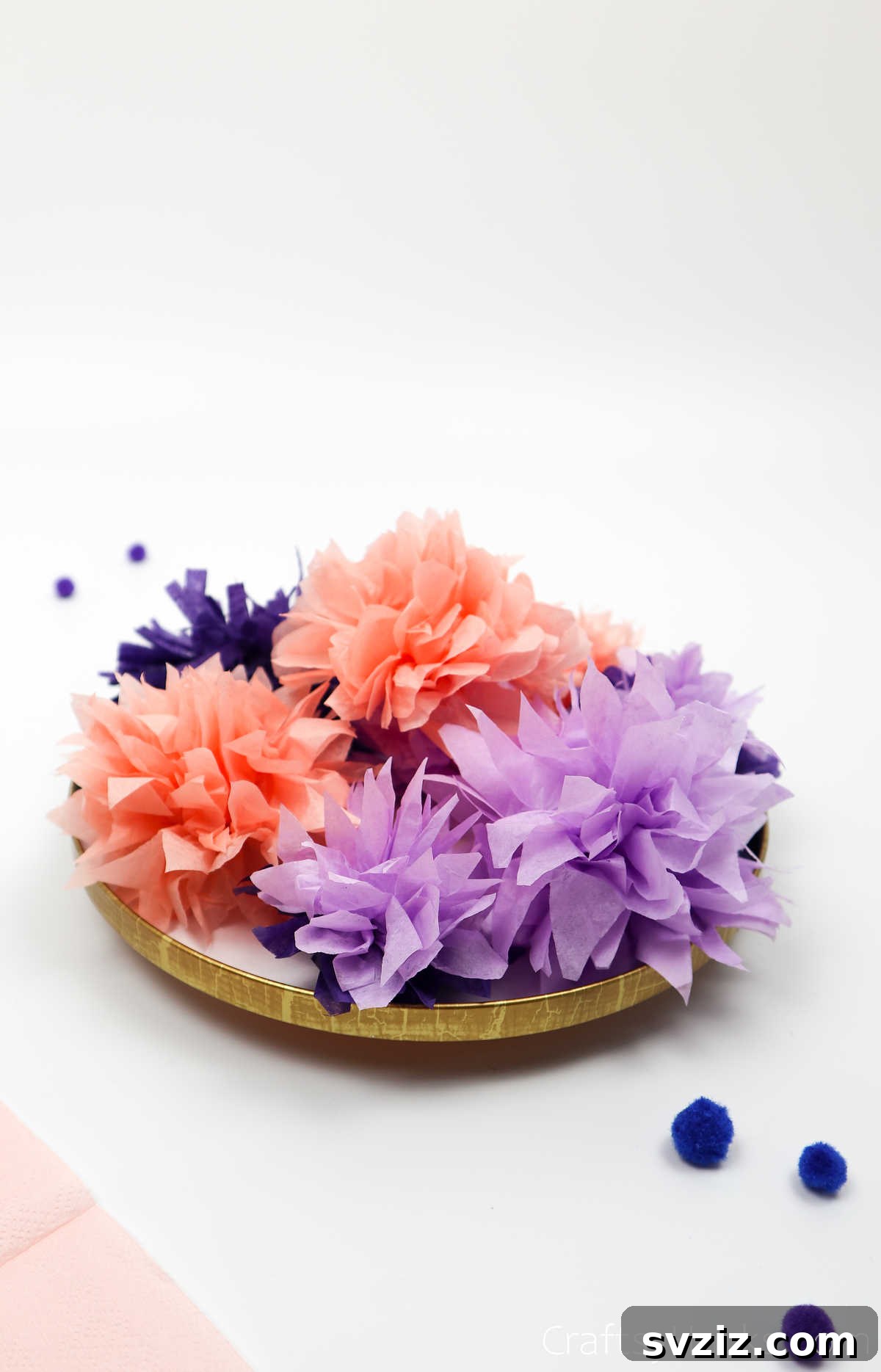 A beautifully arranged bowl filled with various colors of tissue paper flowers, serving as a charming centerpiece