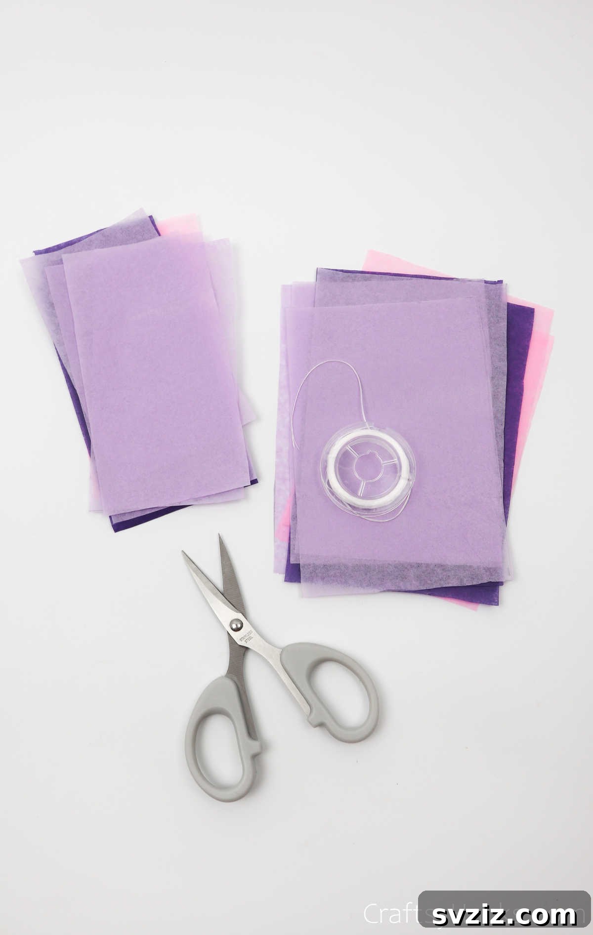 Neatly arranged craft supplies, including stacks of colorful tissue paper, scissors, and thread, ready for making DIY flowers