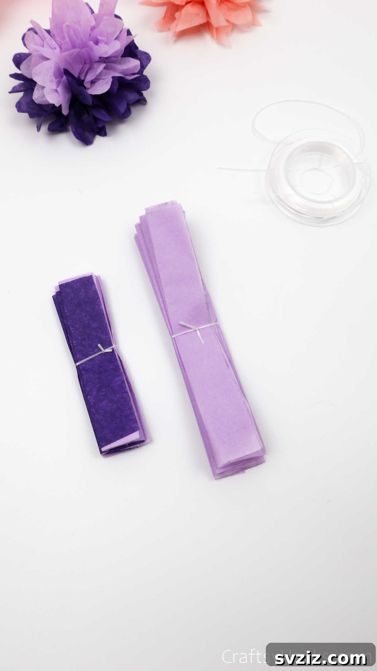 Two neatly tied bundles of folded tissue paper, demonstrating the secured midpoint for flower crafting