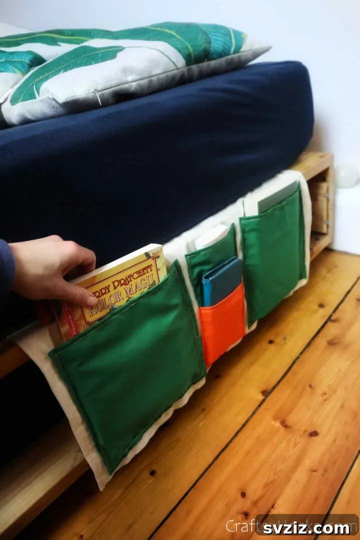 Effortless Stitching: 47 Projects for Every Skill Level 3 A fabric bedside caddy hanging from a bed frame, filled with books, a tablet, and a remote control.