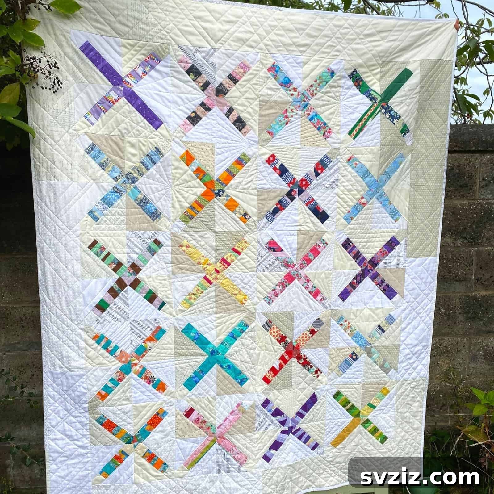 Effortless Stitching: 47 Projects for Every Skill Level 39 A colorful patchwork quilt made from various fabric scraps, forming an 'X' pattern.