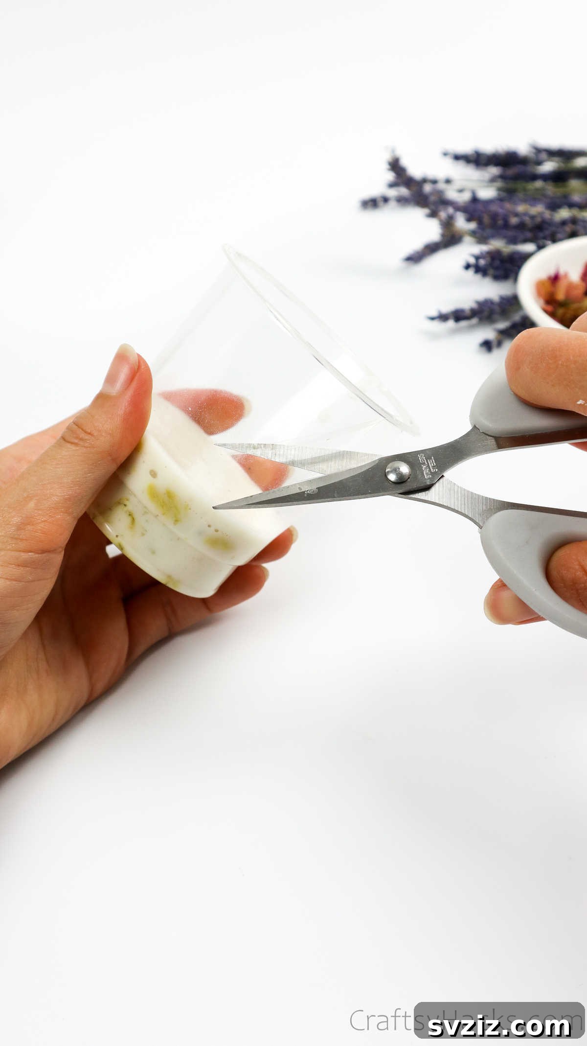 Your Guide to Crafting Homemade Soap 20 Carefully cutting a plastic cup to release a hardened soap bar