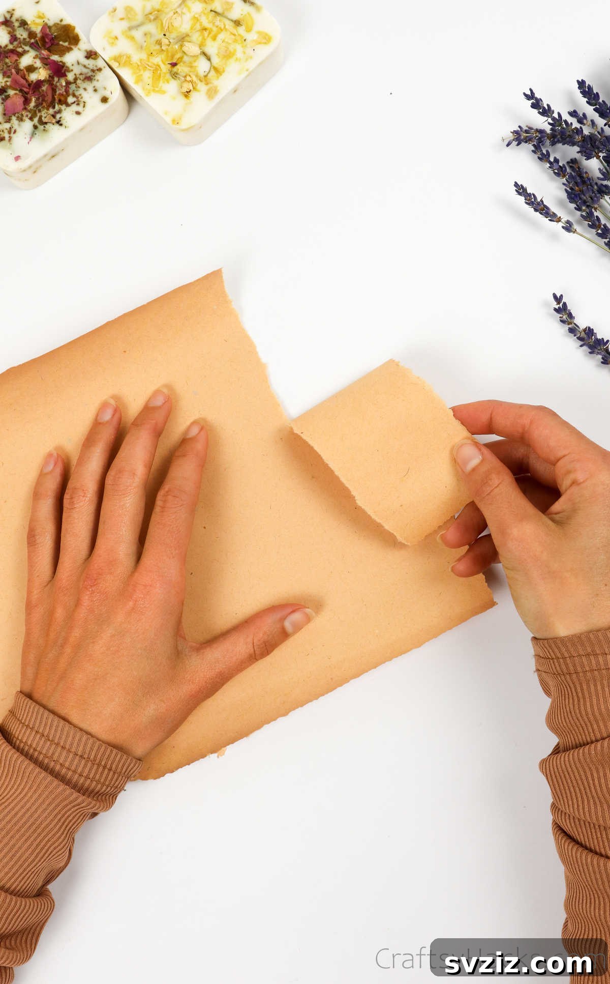 Your Guide to Crafting Homemade Soap 25 Tearing a piece of craft paper for wrapping homemade soap