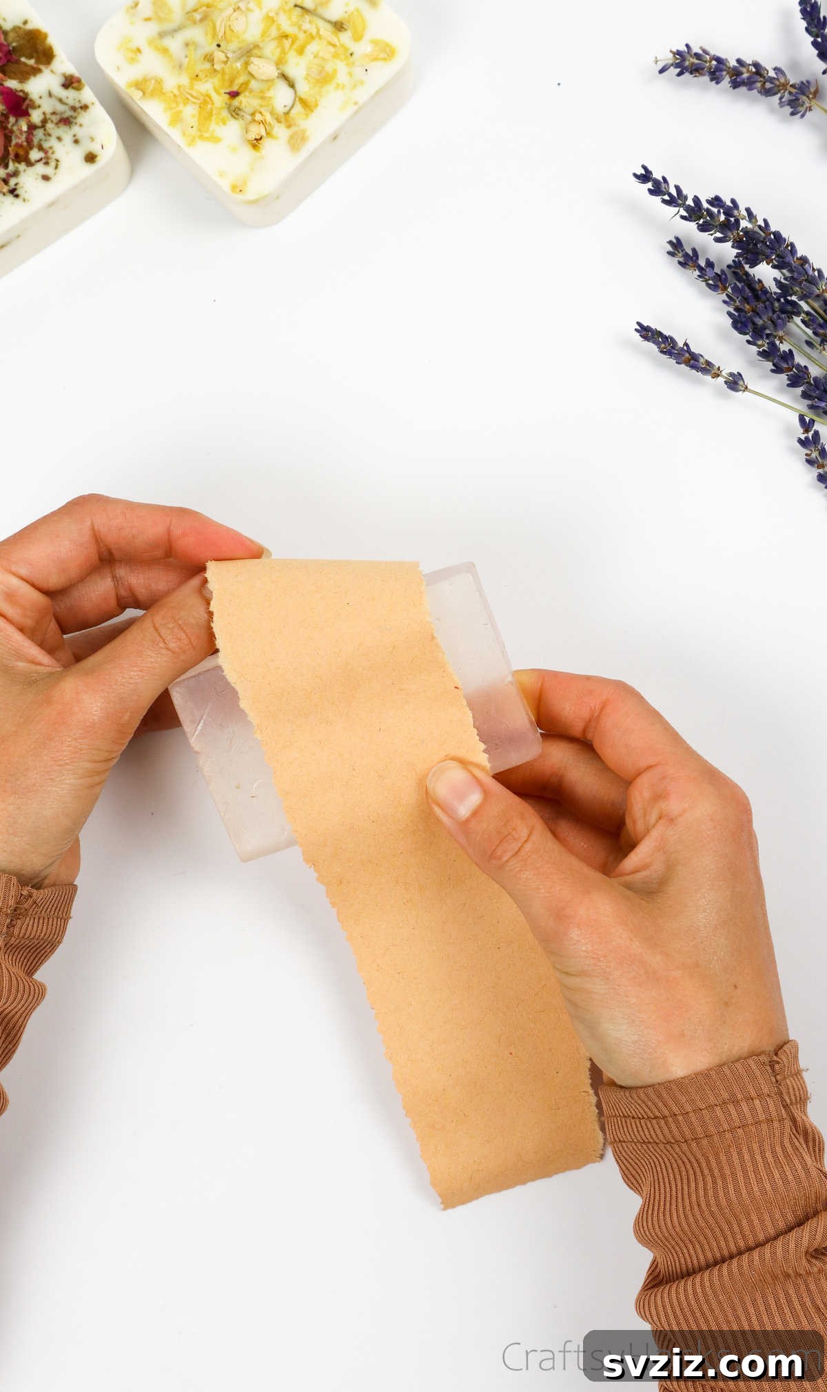 Your Guide to Crafting Homemade Soap 26 Wrapping a handmade soap bar carefully with craft paper