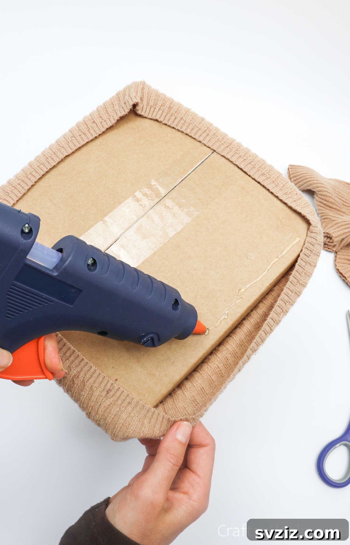 Applying hot glue to the bottom edge of the box