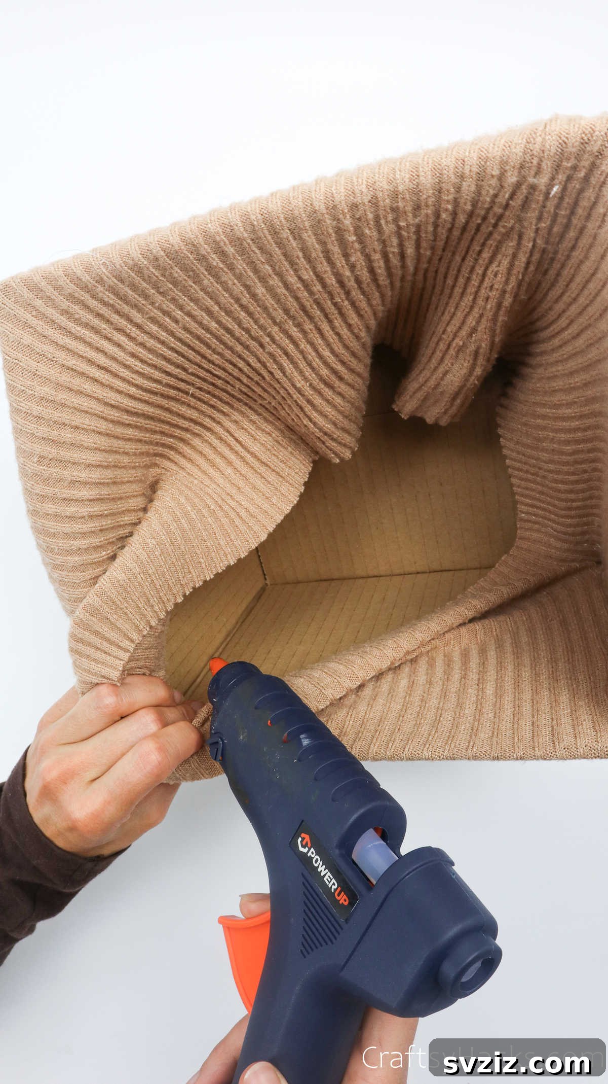Applying hot glue to an interior corner of the box