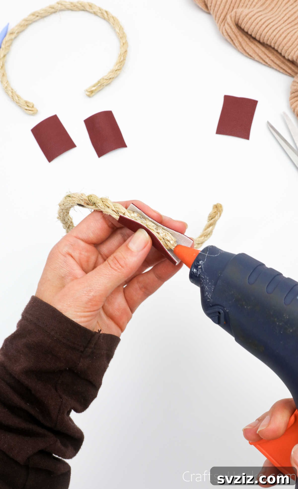 Applying hot glue to secure leather to rope