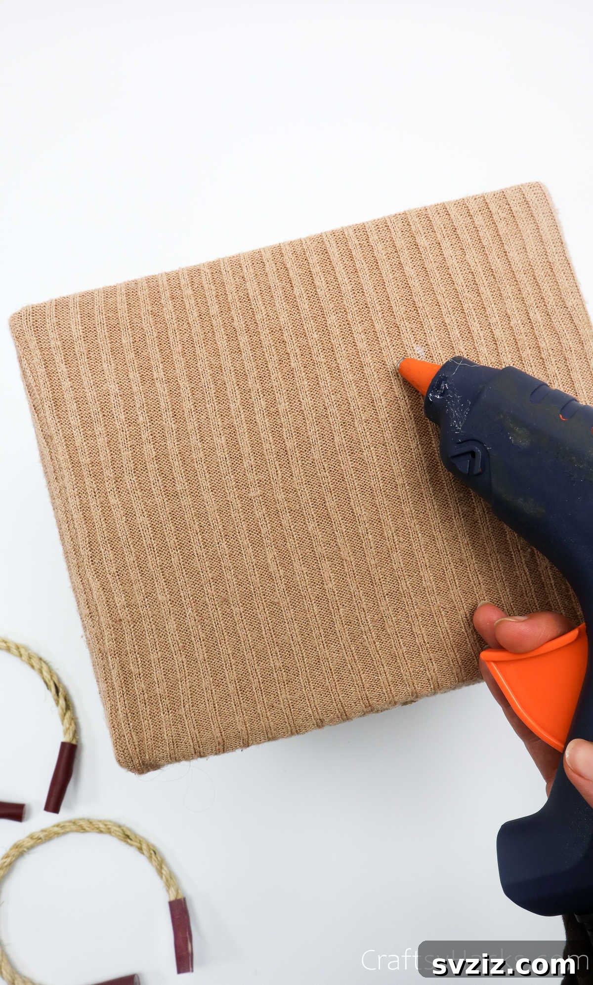 Applying hot glue to the side of the box for handle attachment