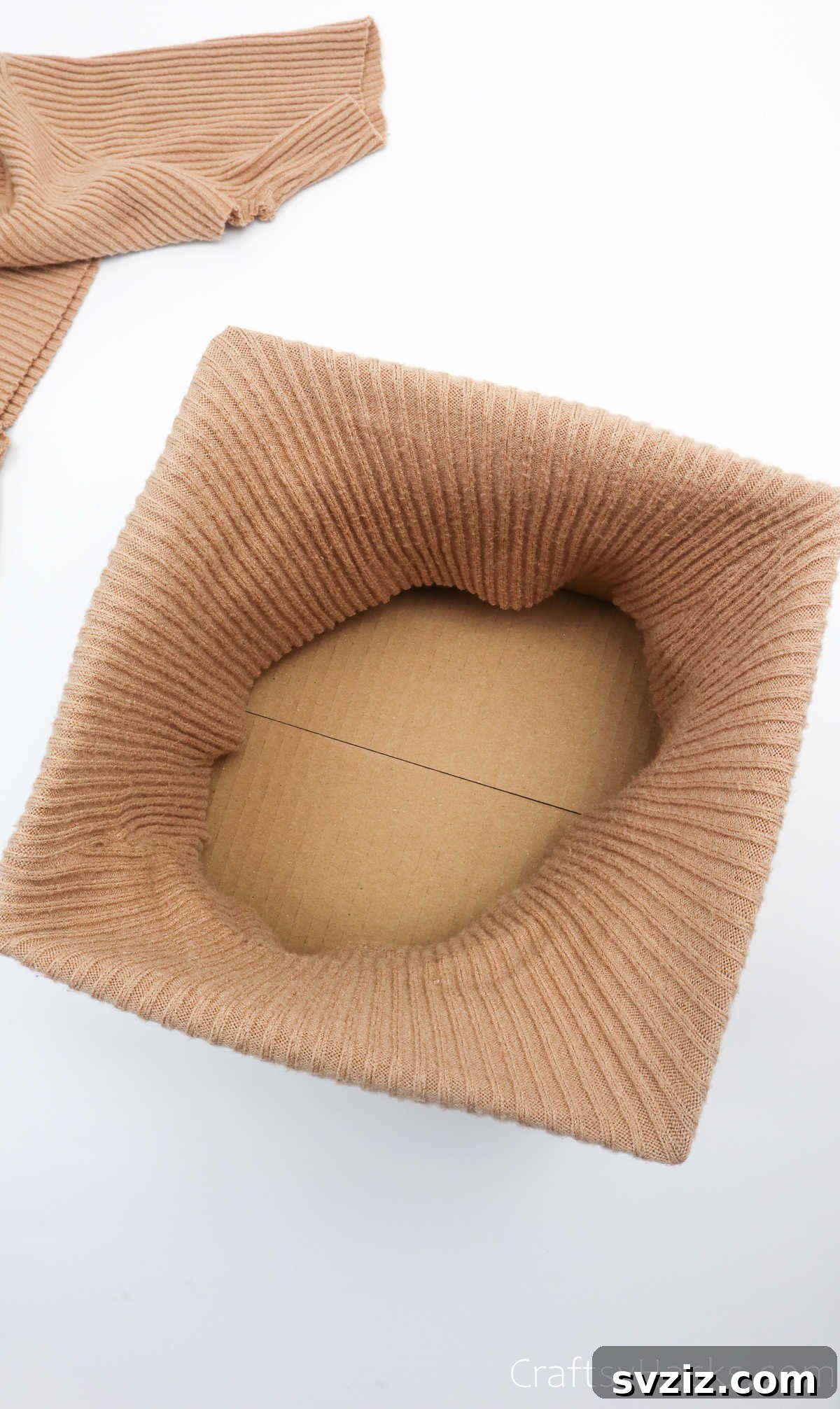 Top view of a box with a sweater pulled over, showing internal placement