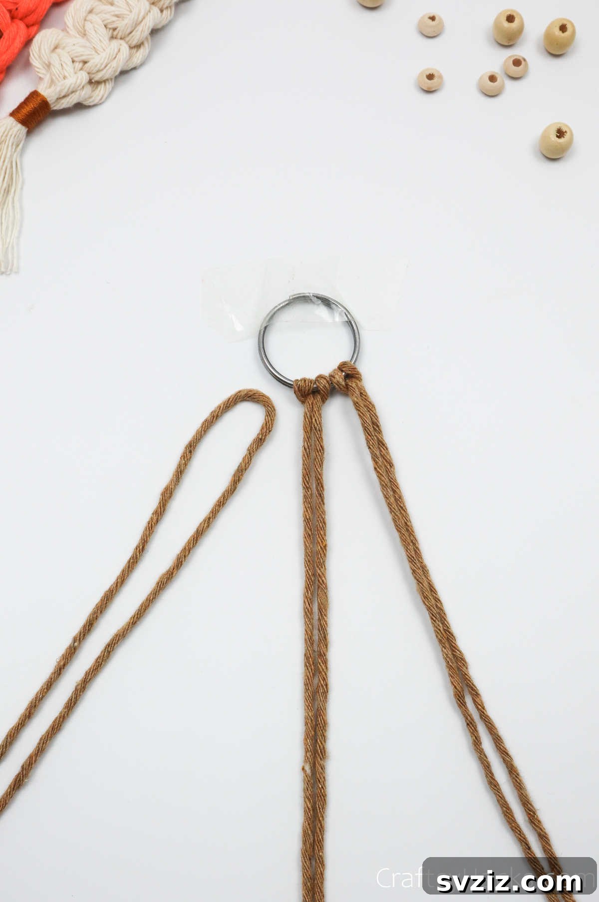 A second macrame cord successfully attached to the key ring with a lark's head knot.