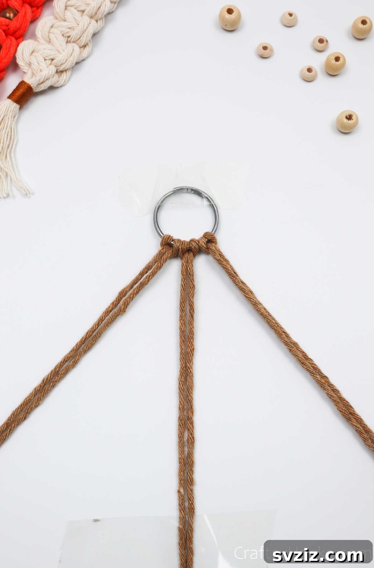 Close-up of the taped-down middle macrame cords, creating a stable base for knotting.