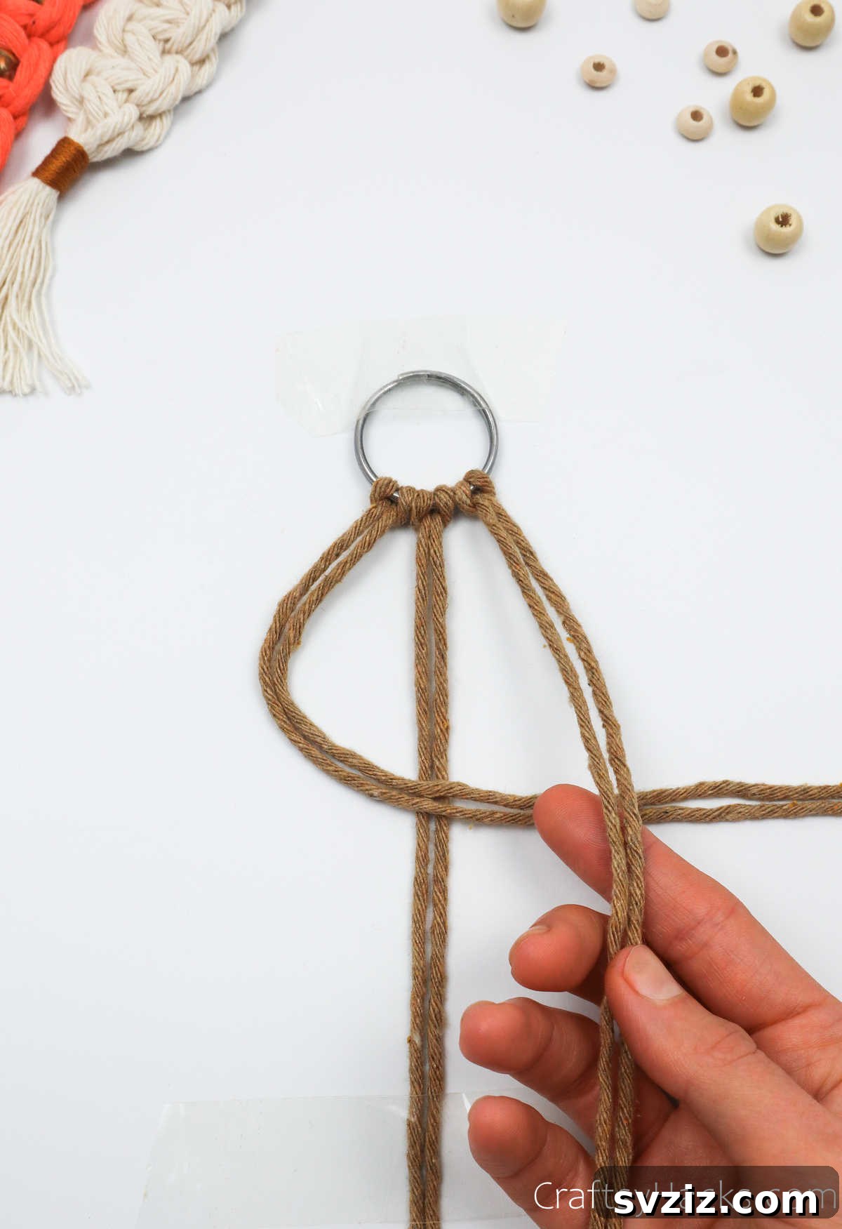 The right two macrame cords are positioned over the left cords, initiating the square knot.