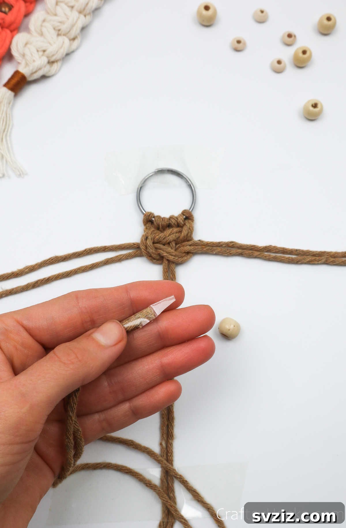 The ends of the middle macrame cords are taped for easier threading of beads.