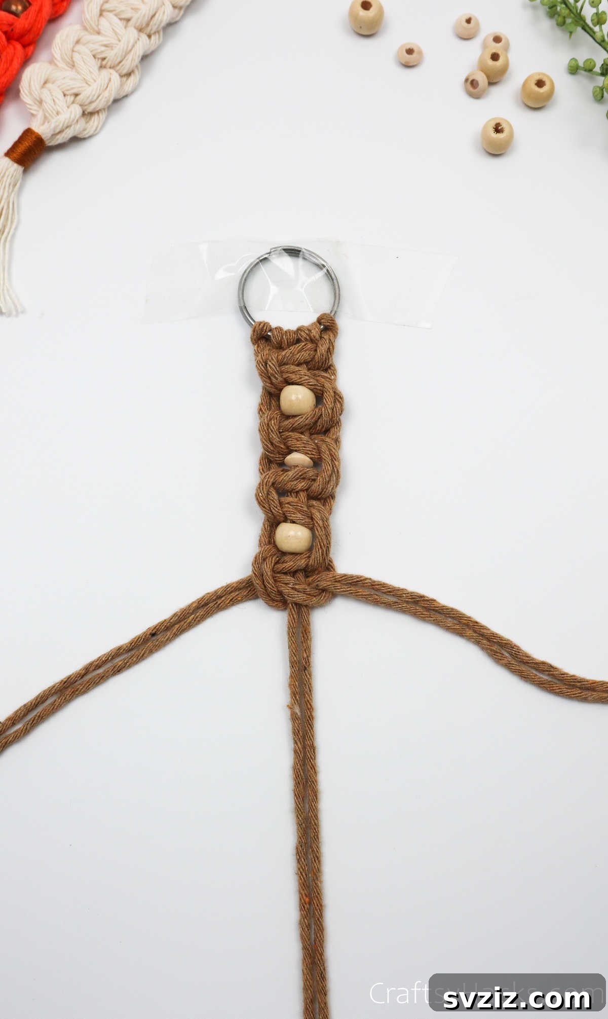 A section of the macrame keychain showing multiple beads secured by square knots.