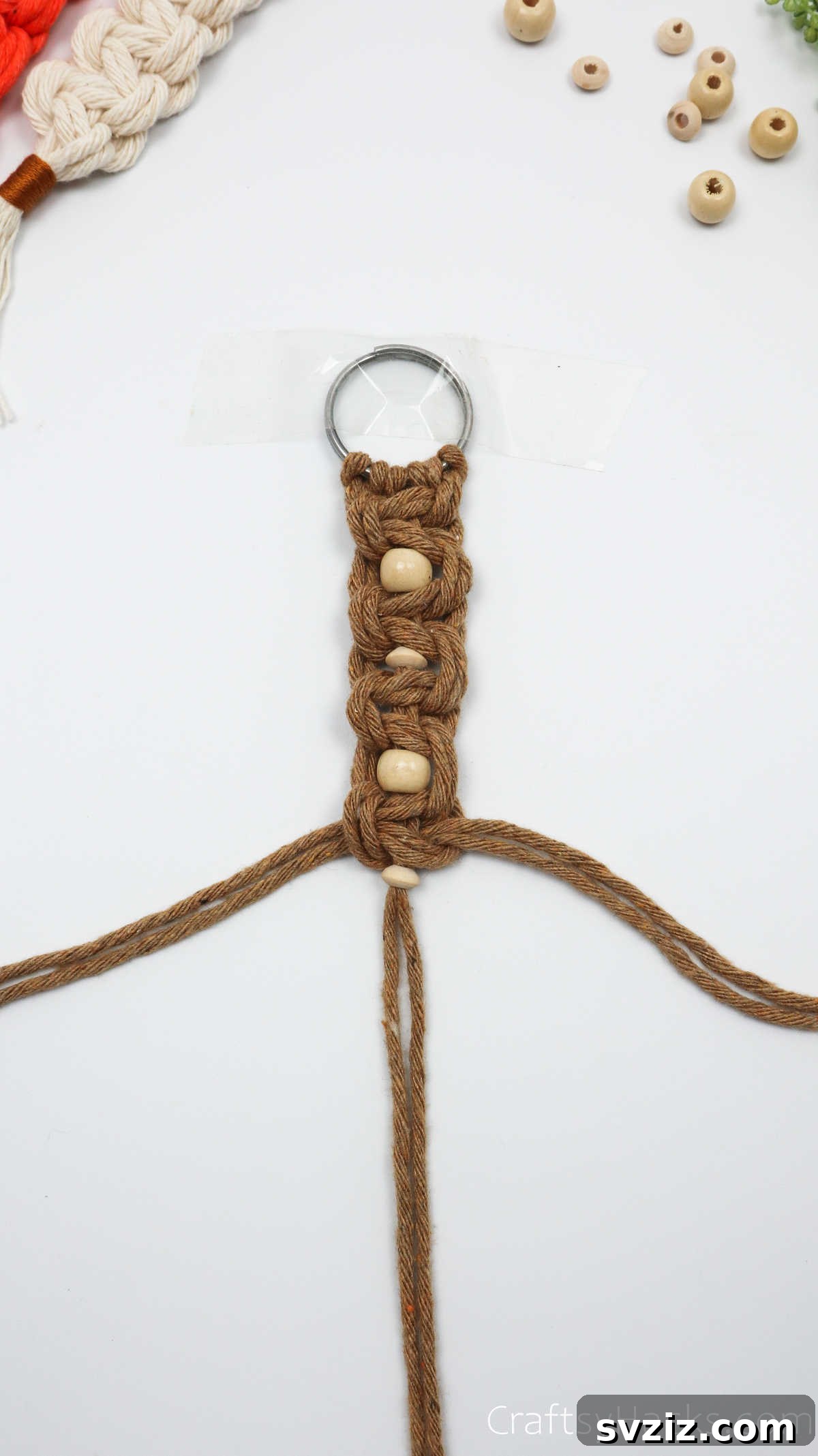 Adding a fourth bead to the macrame keychain.