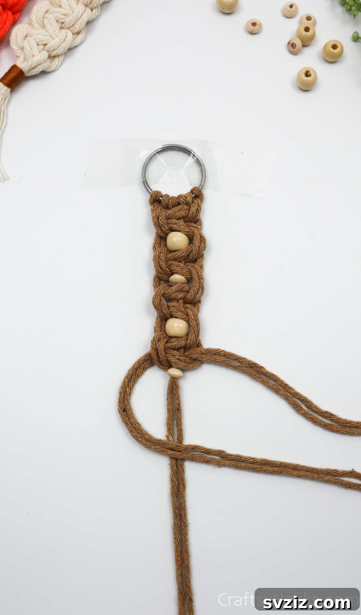 Tying the square knot below the fourth bead.