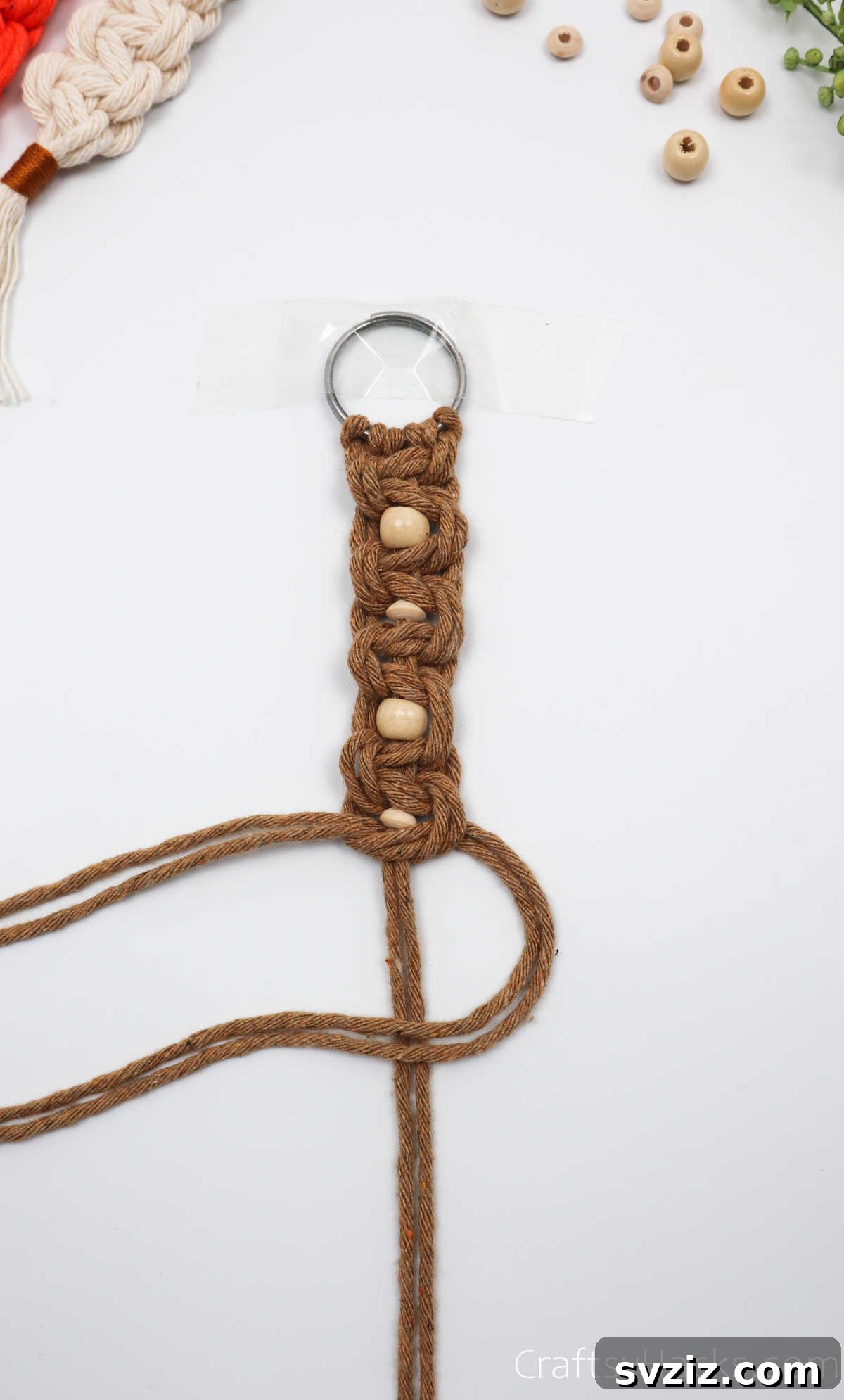 The completed set of macrame square knots and beads, forming the body of the keychain.