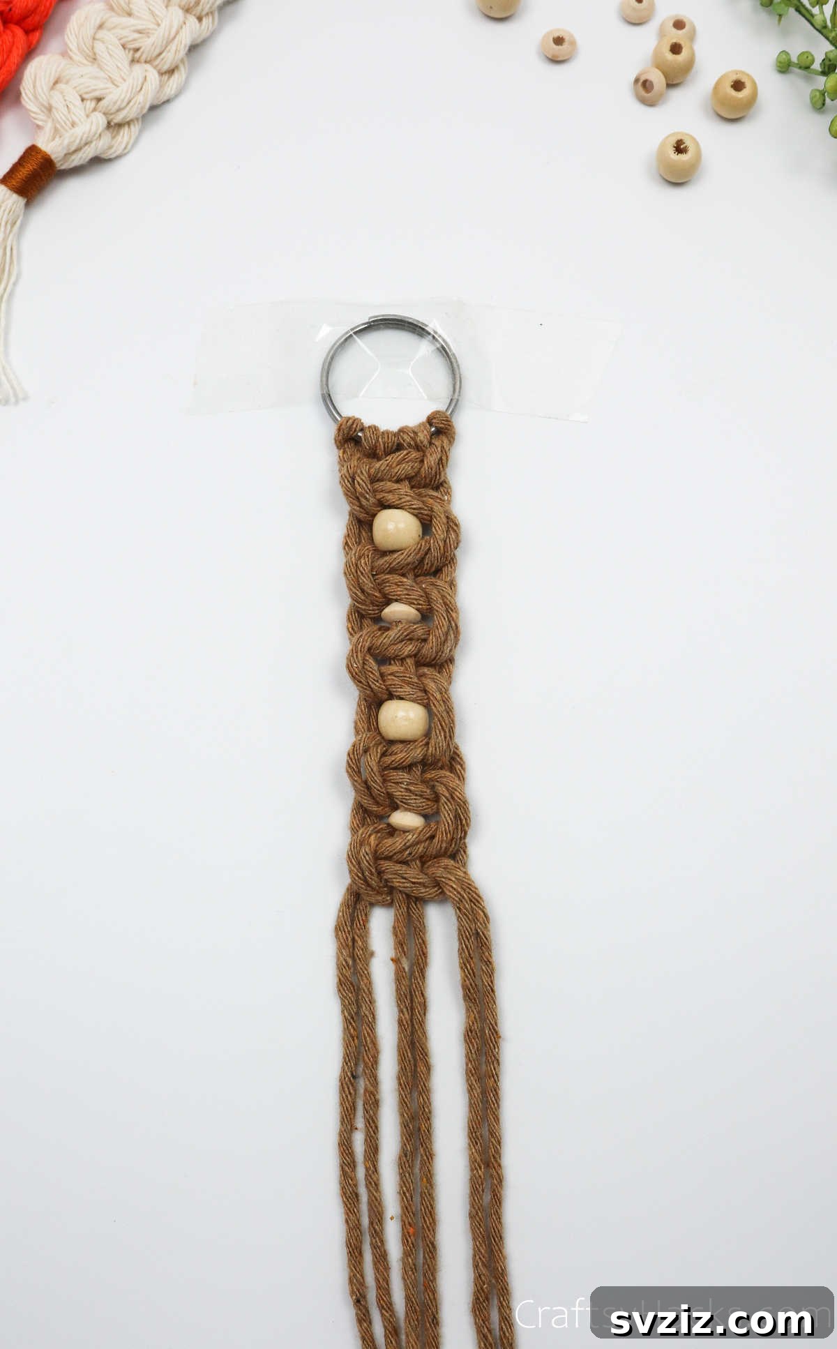 The full length of the macrame keychain with all knots and beads completed, ready for the final steps.