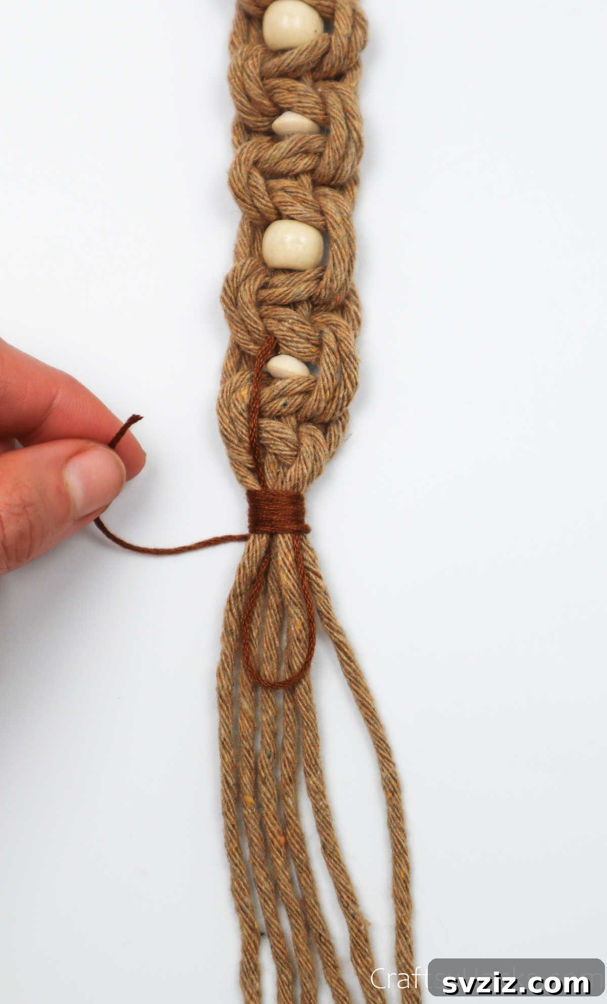 The wrapping thread is pulled through the initial 'U' loop to secure the wrap.
