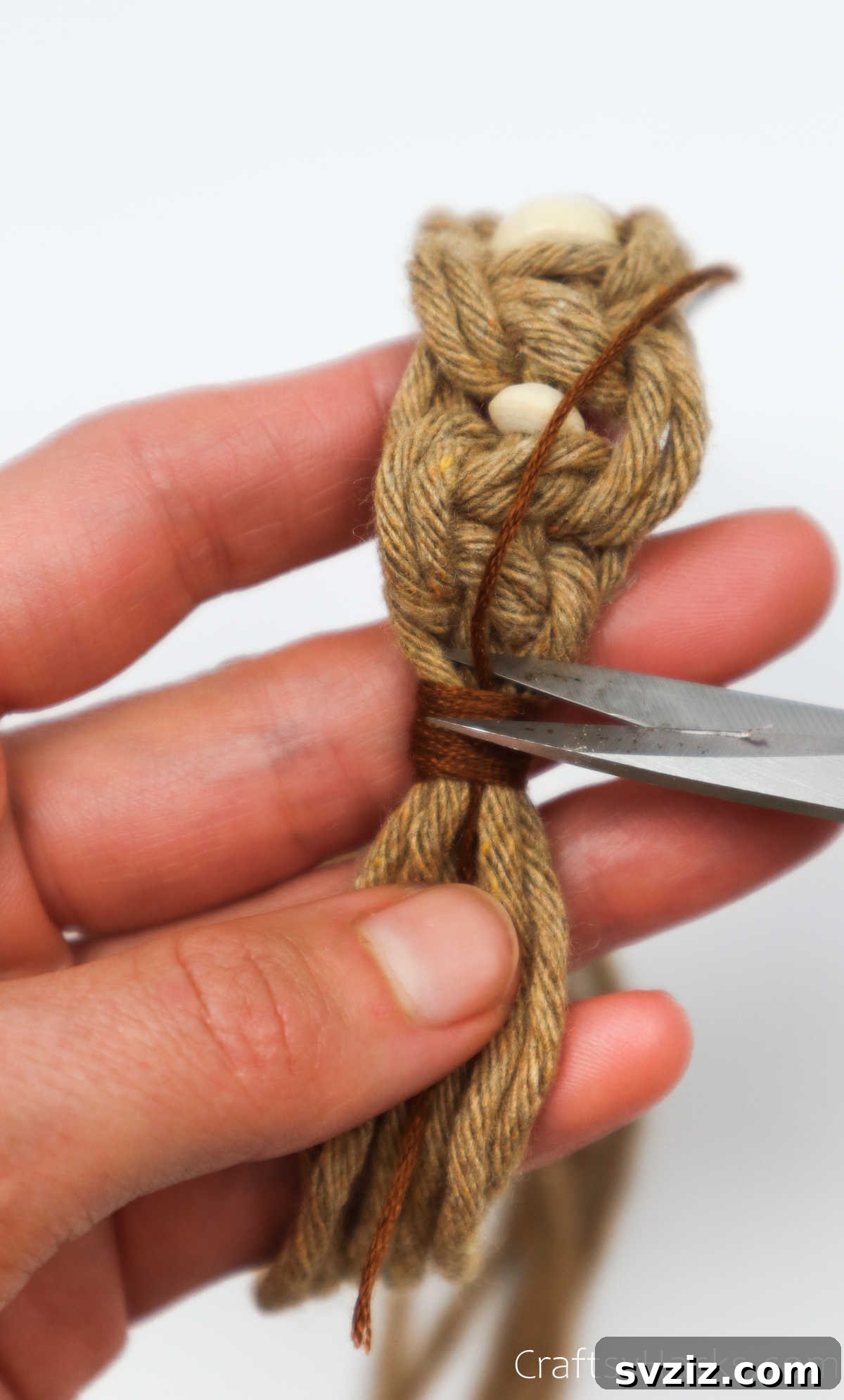 Trimming the excess ends of the embroidery thread for a clean finish.