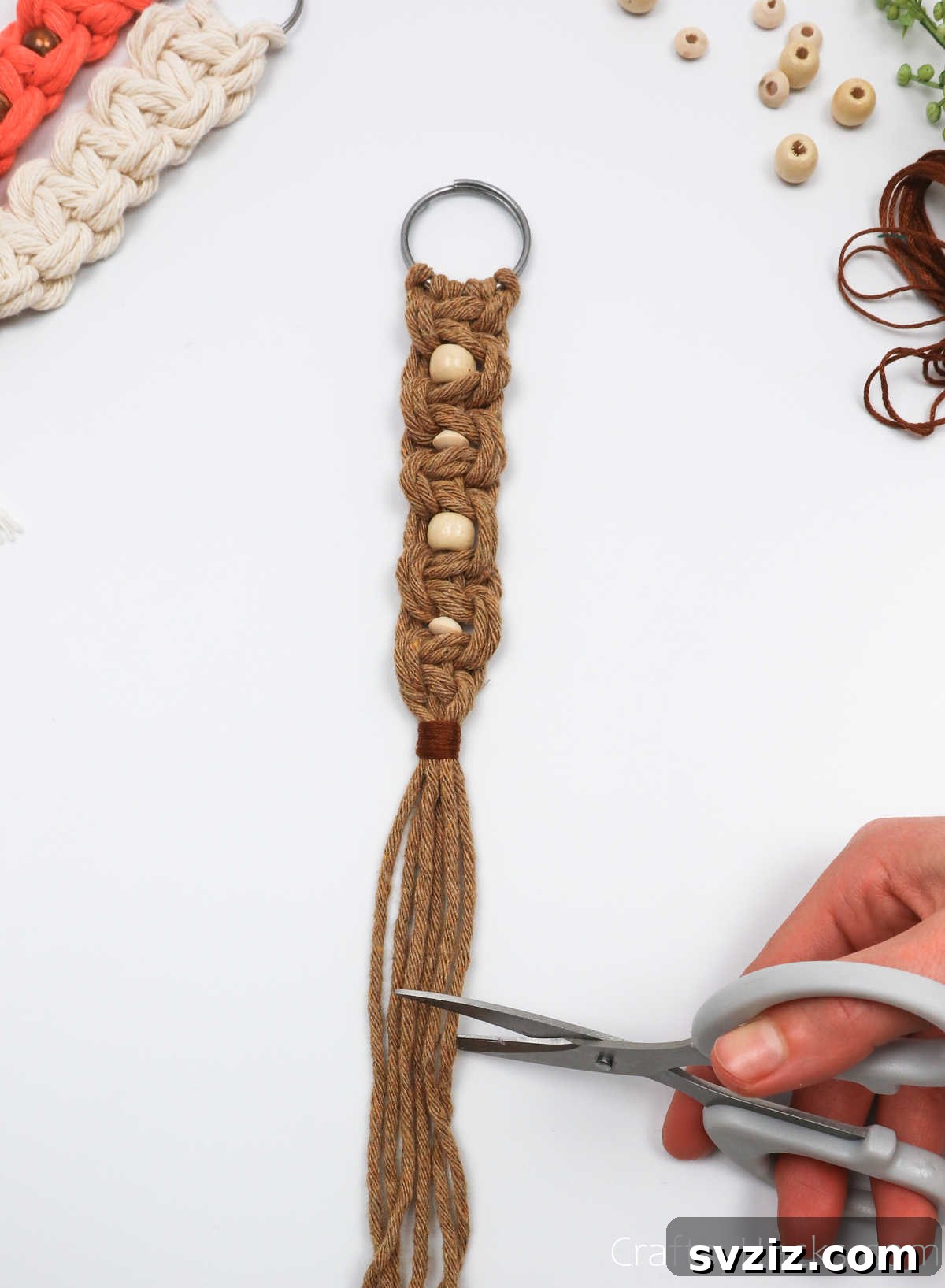 Trimming the ends of the macrame cords evenly to prepare for the tassel.