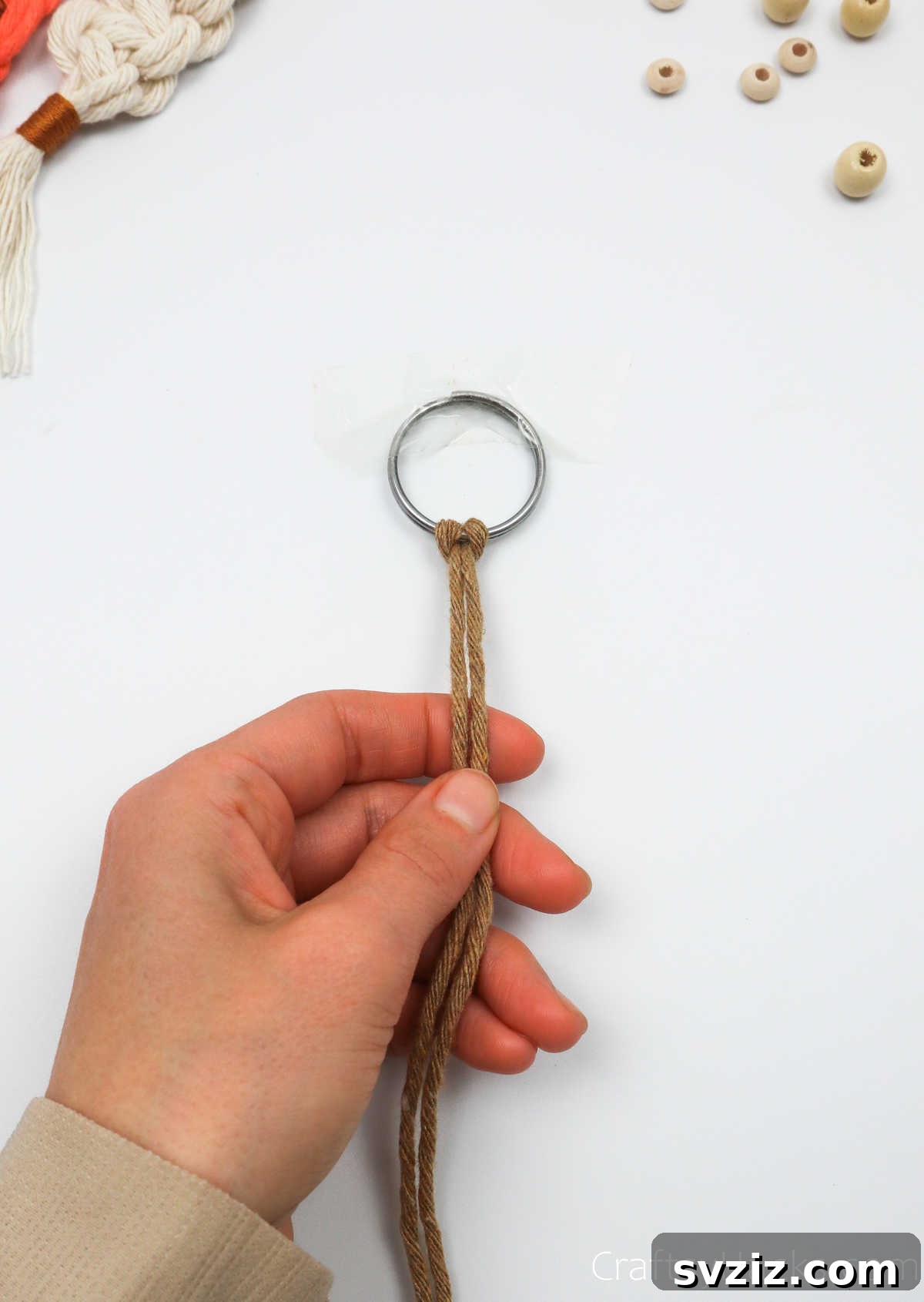 A completed lark's head knot securing a macrame cord to a key ring.