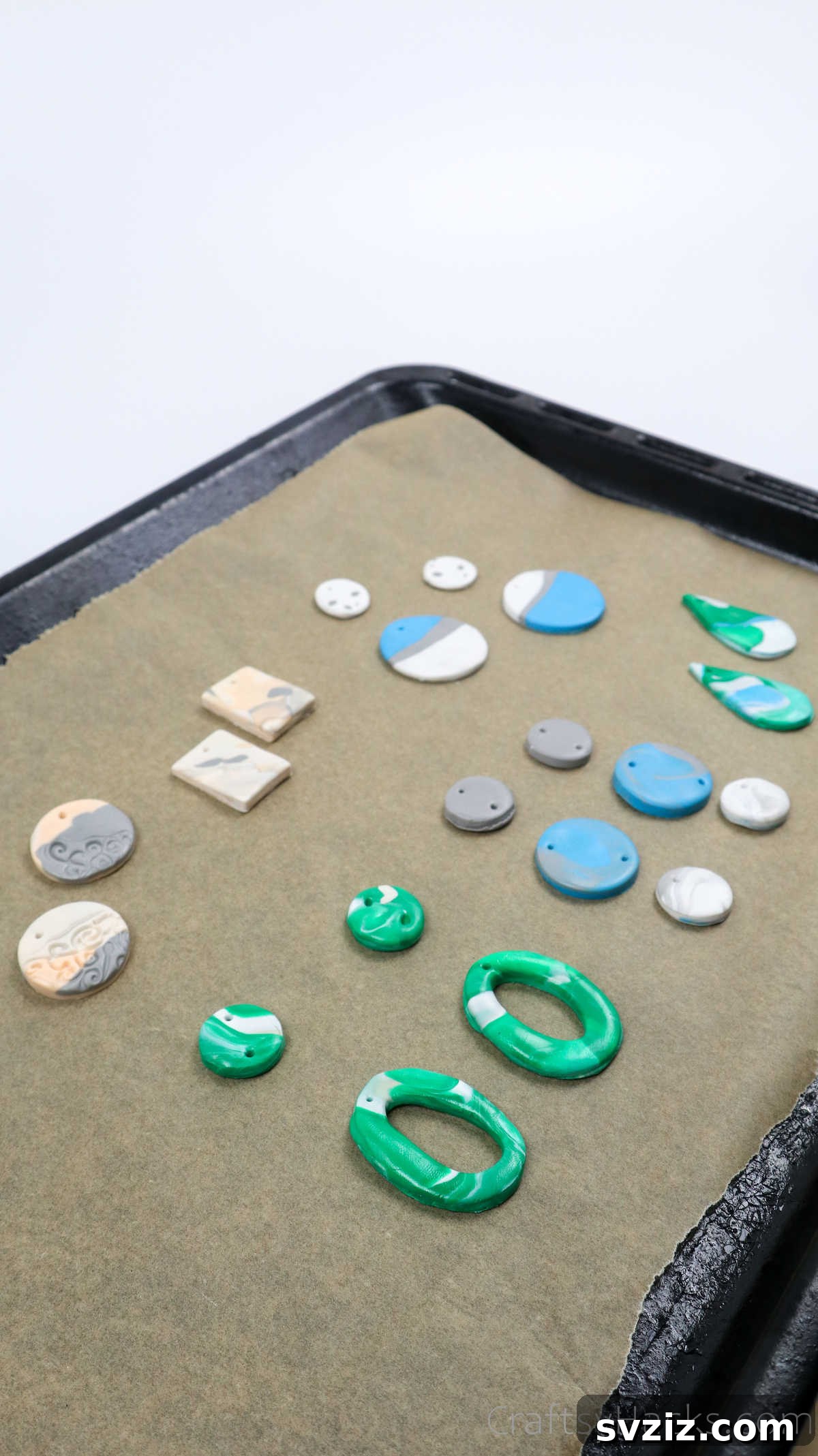 Craft Your Own Polymer Clay Earrings 52 Polymer clay earrings arranged on a baking sheet