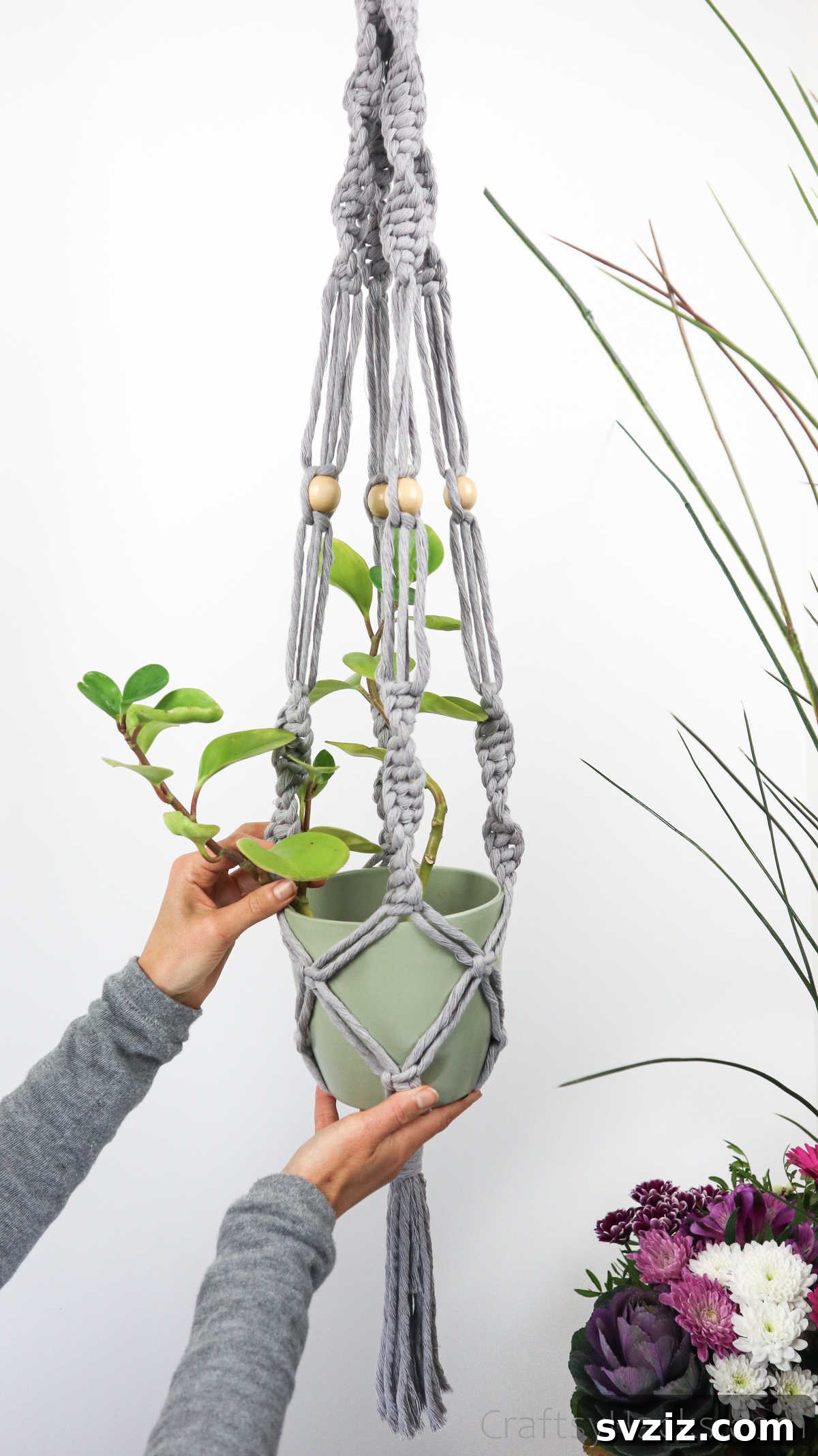 Craft Your Own Macrame Plant Hanger A Complete Guide 14 Person proudly holding a completed macrame plant hanger, showcasing its size and intricate design.