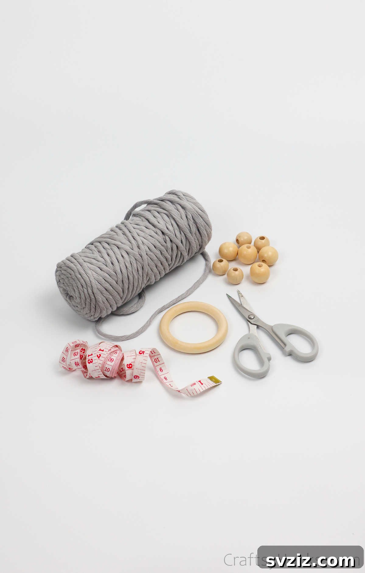 Craft Your Own Macrame Plant Hanger A Complete Guide 3 Arrangement of macrame craft supplies including cotton cord, wooden ring, scissors, and decorative beads.