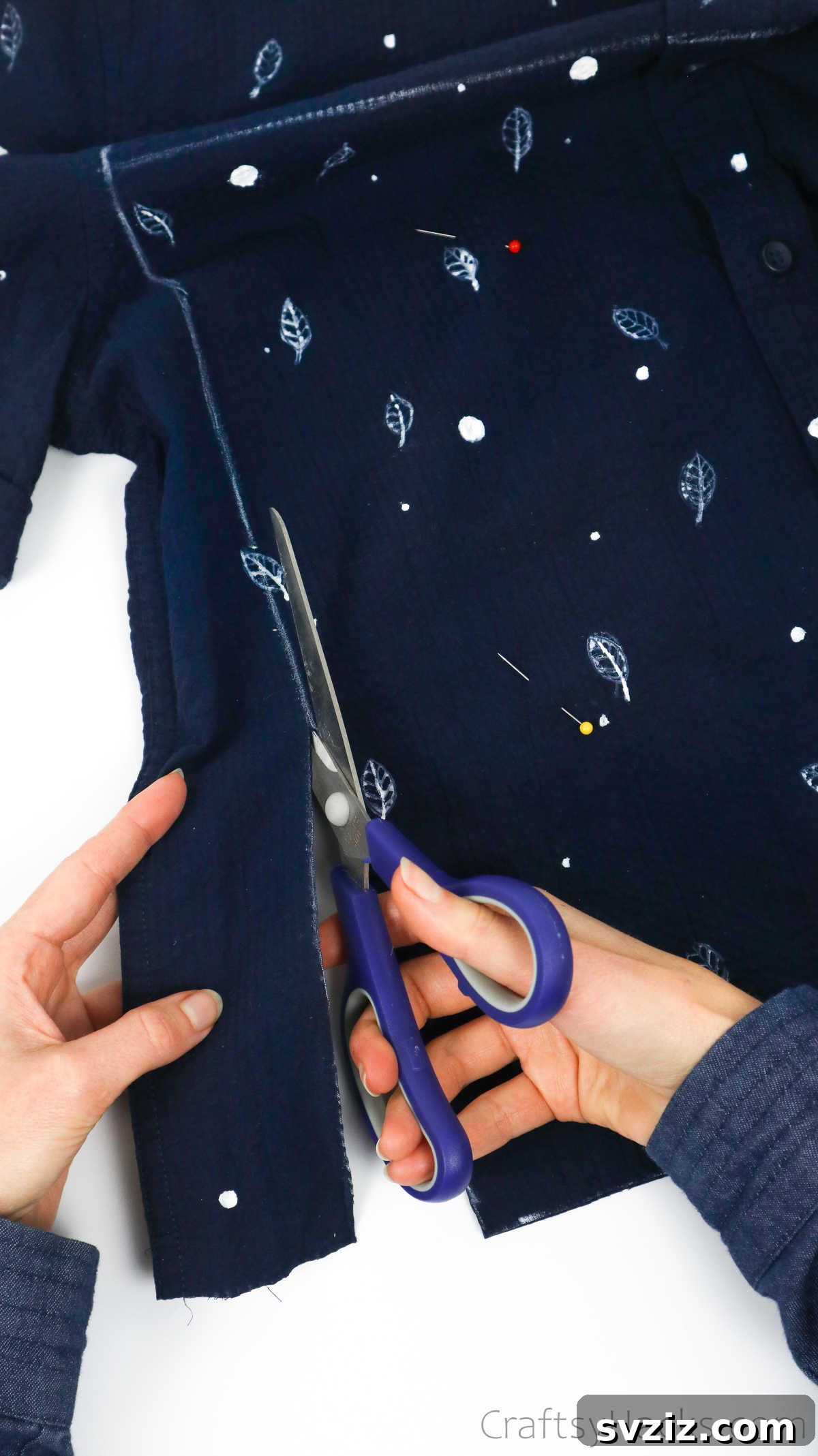 Scissors cutting a shirt along marked lines, showing the precise action for tote bag creation