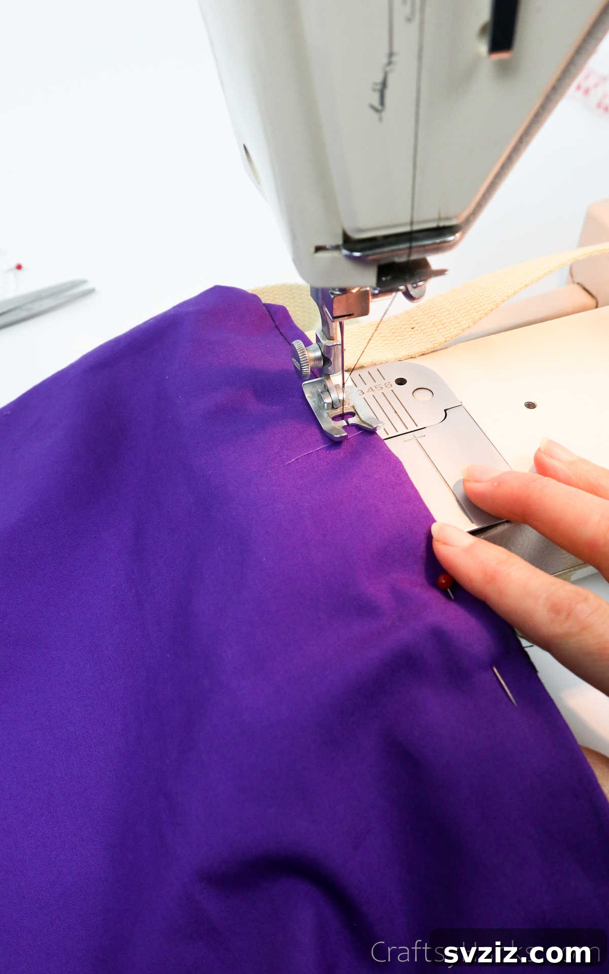 Sewing machine stitching along the top edge of the tote bag, securing all layers and straps