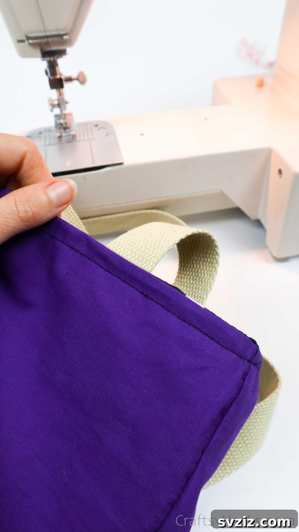 Reinforcing the tote bag straps by sewing, ensuring durability for heavy loads