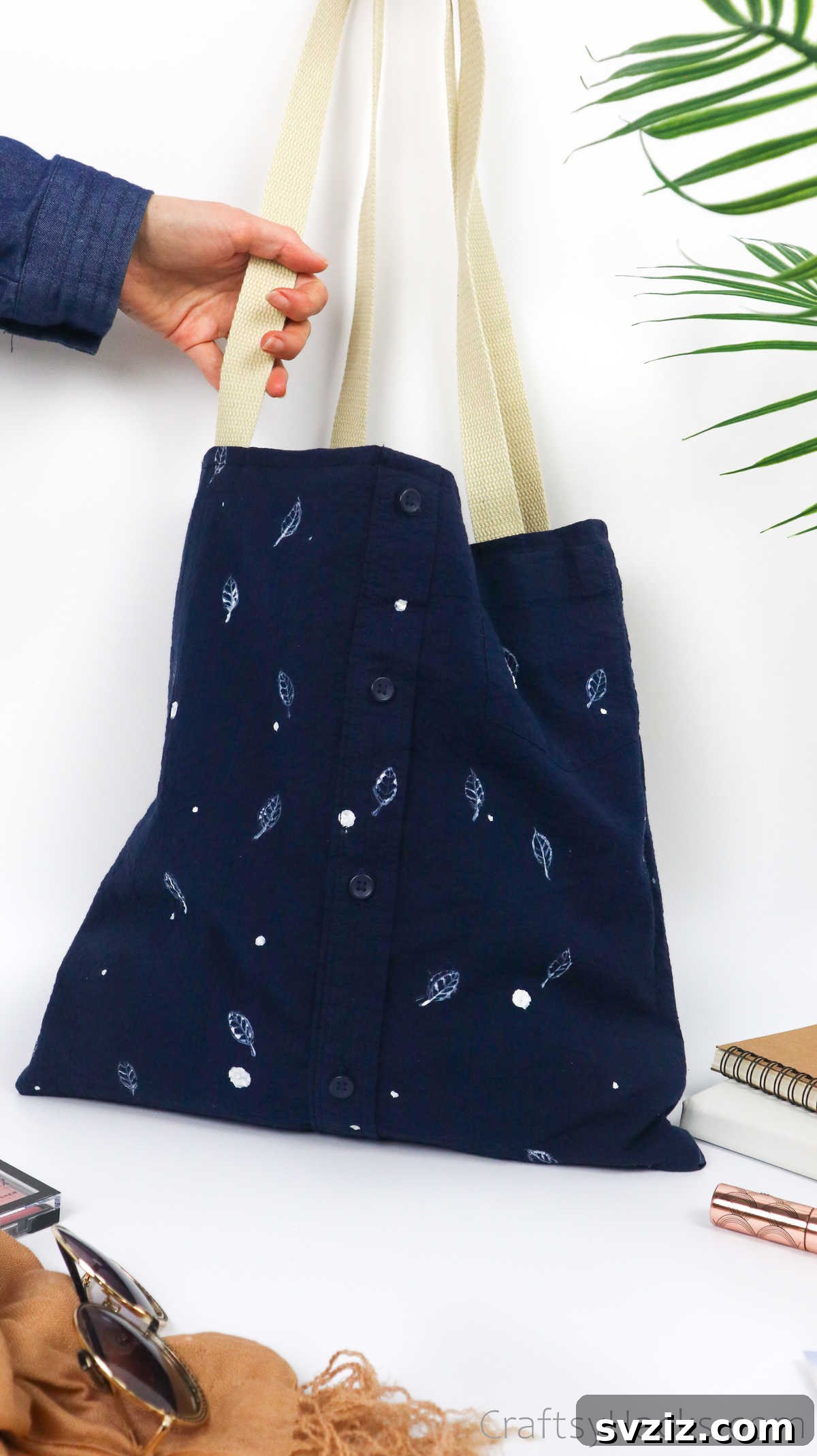 Person holding a completed DIY tote bag from an old shirt, highlighting its practical use