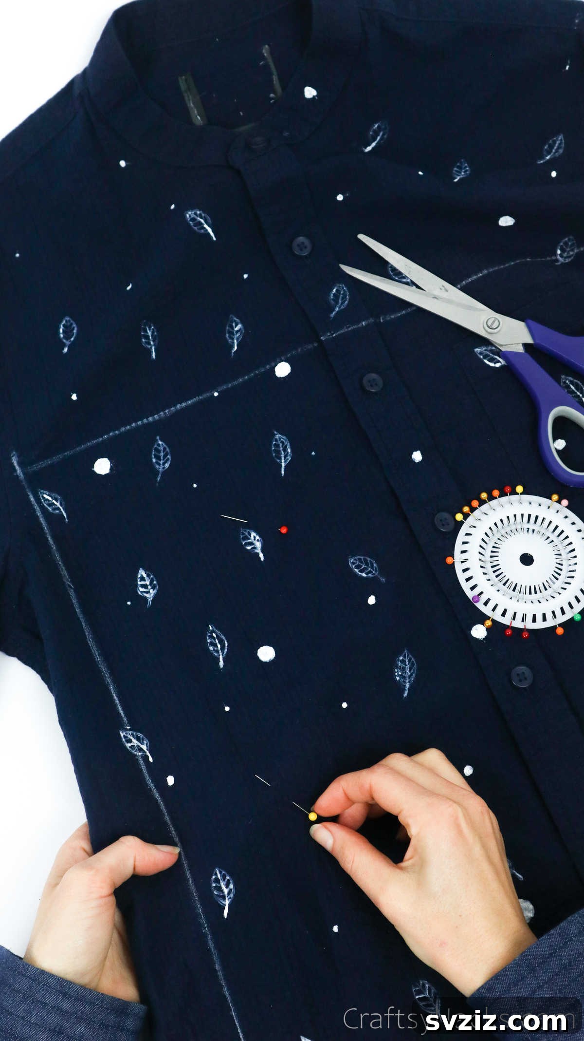 Pinning a shirt along a traced outline, ensuring fabric stability for cutting