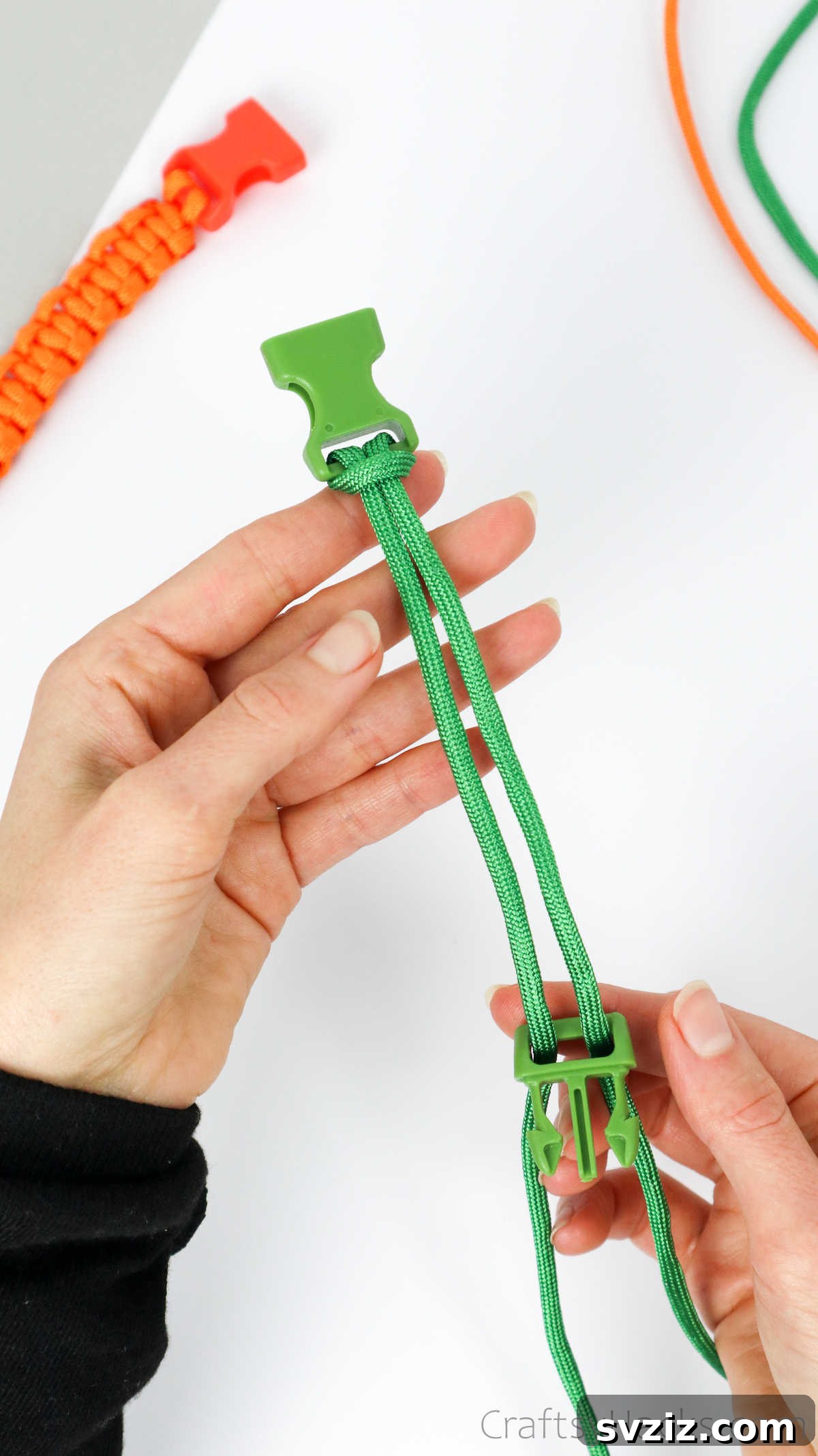 Both buckle halves now connected by two parallel paracord strands, forming the bracelet's core.