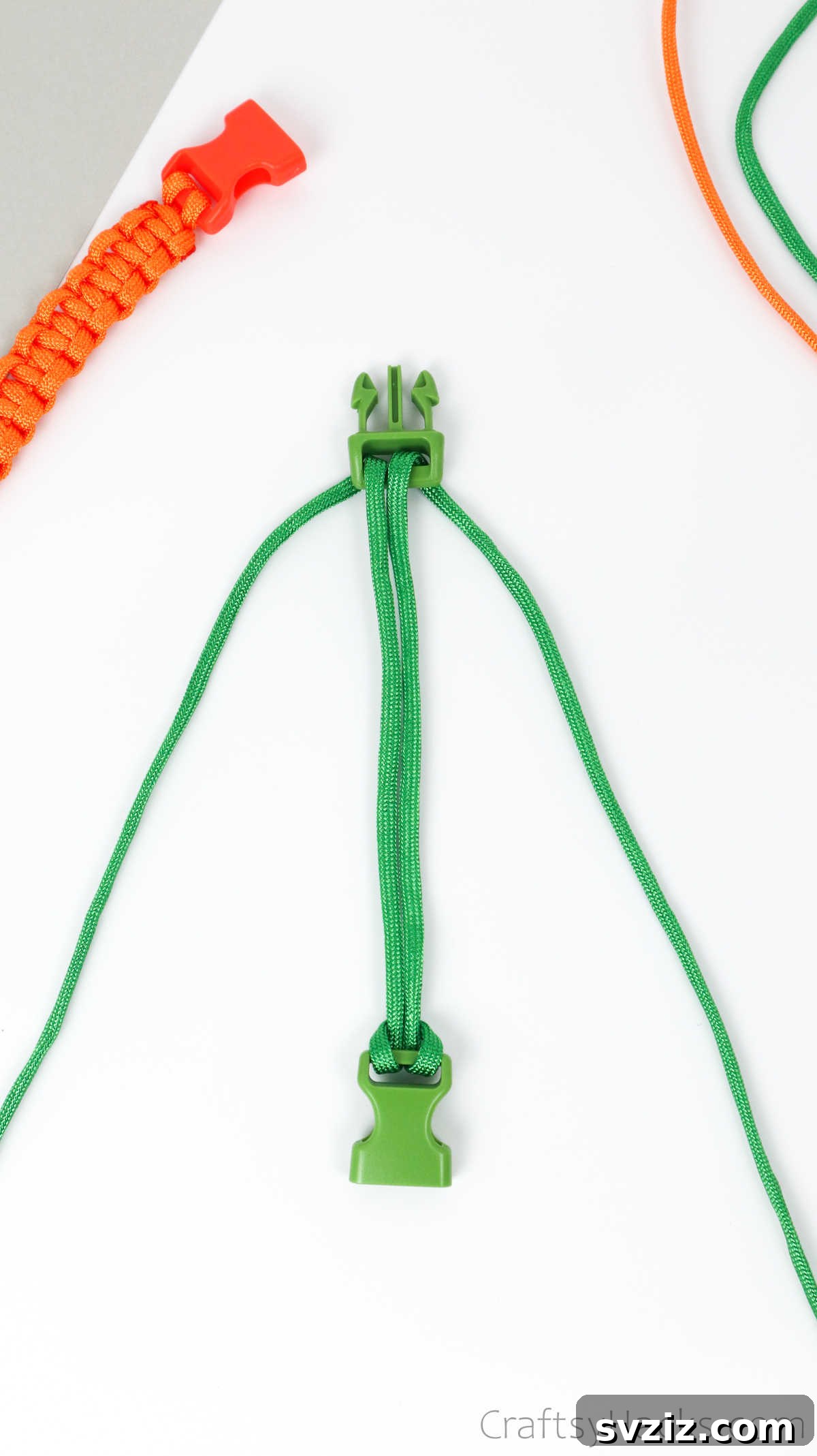The paracord project laid out on a flat surface, with the two buckle halves and central cords in position.
