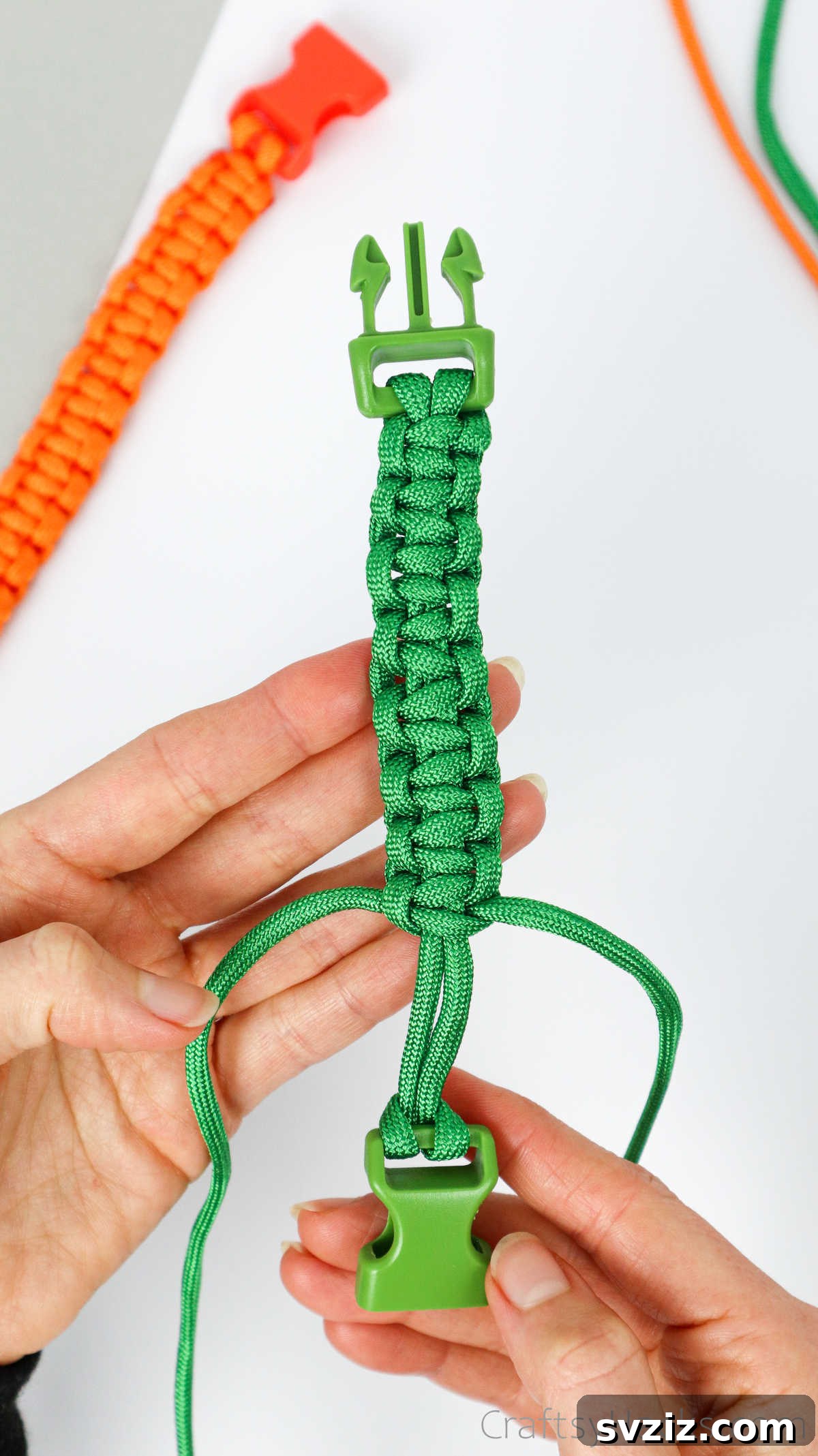 A partially completed paracord bracelet, showing a substantial length of neatly woven square knots.