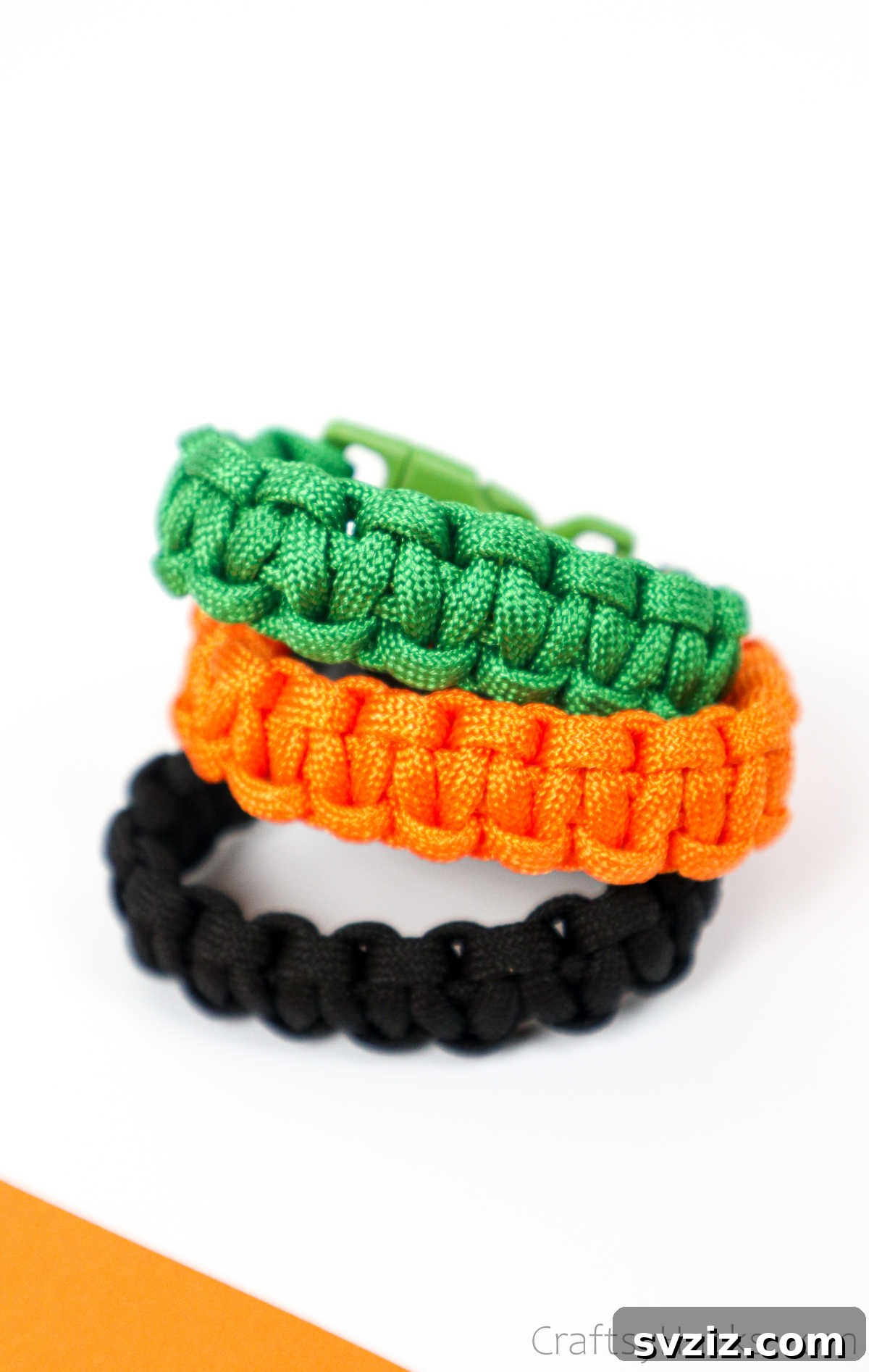 A hand modeling a stack of colorful DIY paracord bracelets, highlighting their stylish and customizable nature.