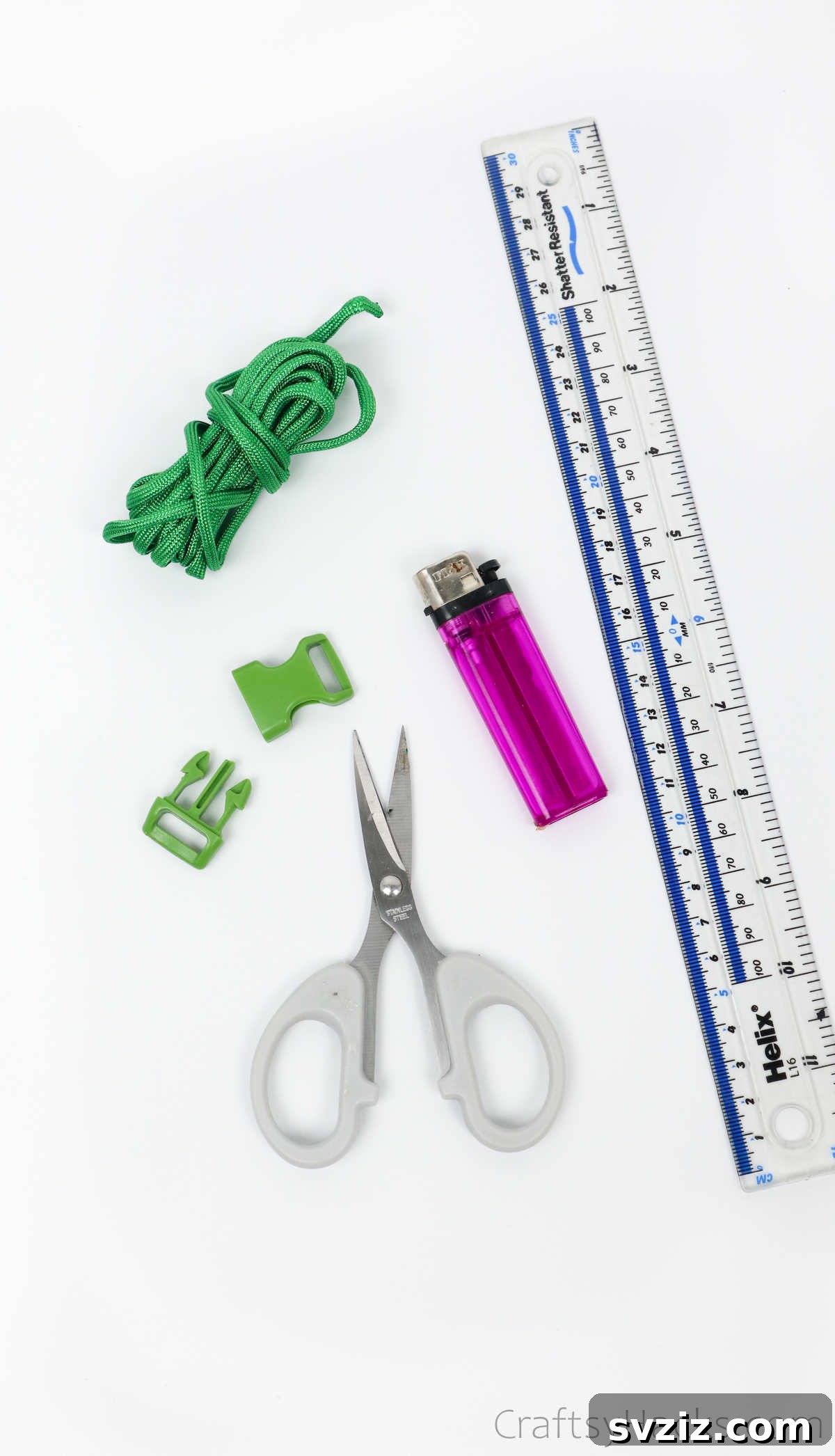 A flat lay of all the crafting supplies needed: colorful paracord, scissors, a lighter, a ruler, and a buckle.