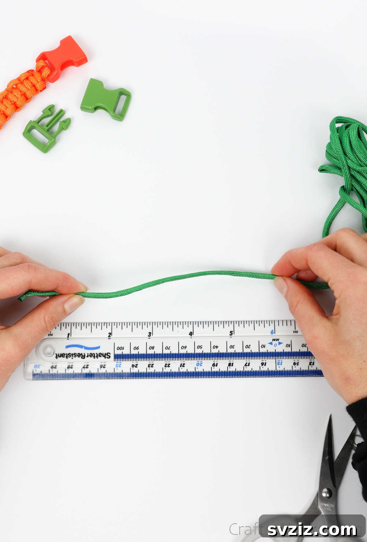 A hand holding a length of paracord against a ruler, precisely measuring its length before cutting.
