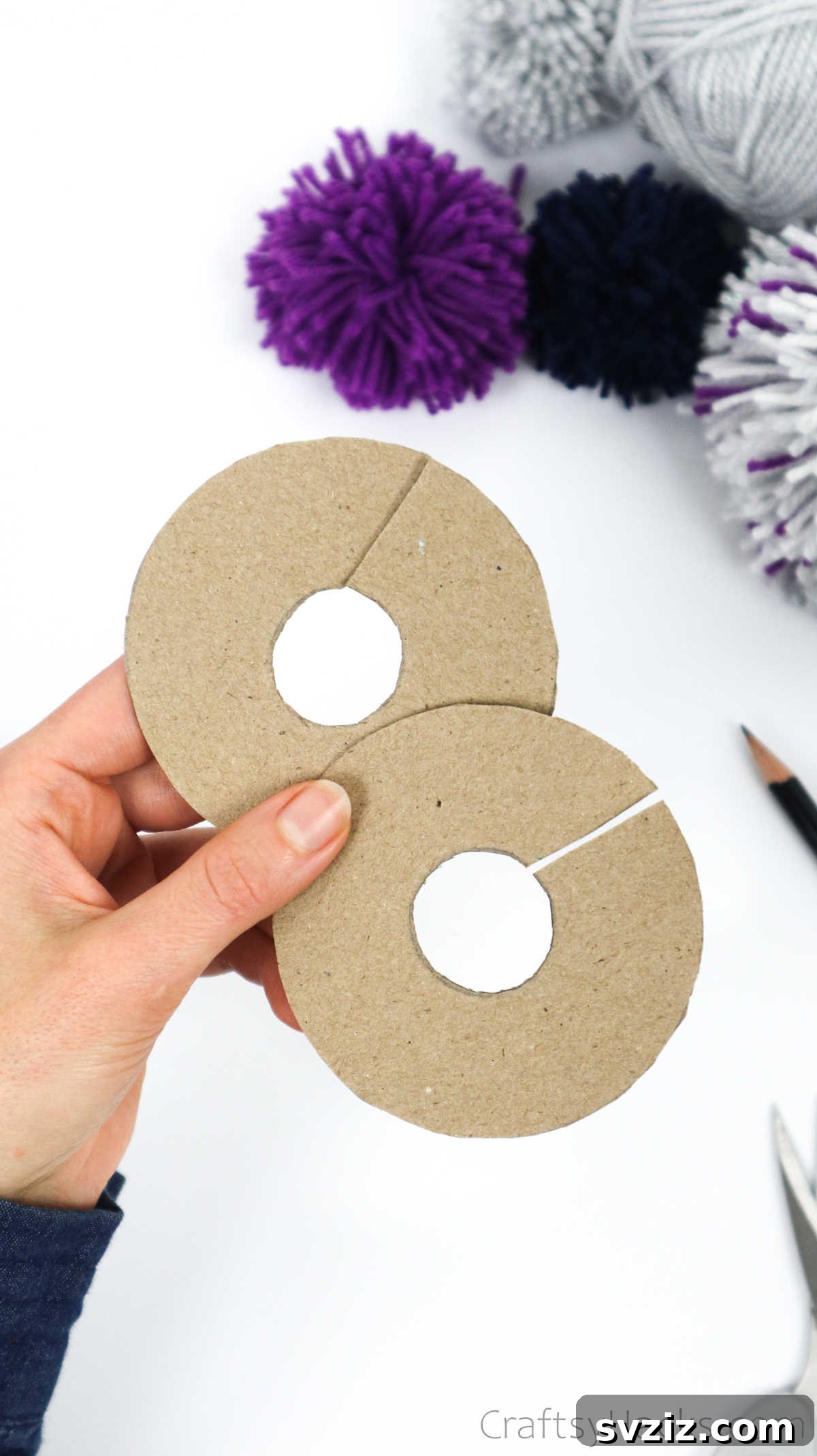 Two identical cardboard donut-shaped disks with an entrance cut