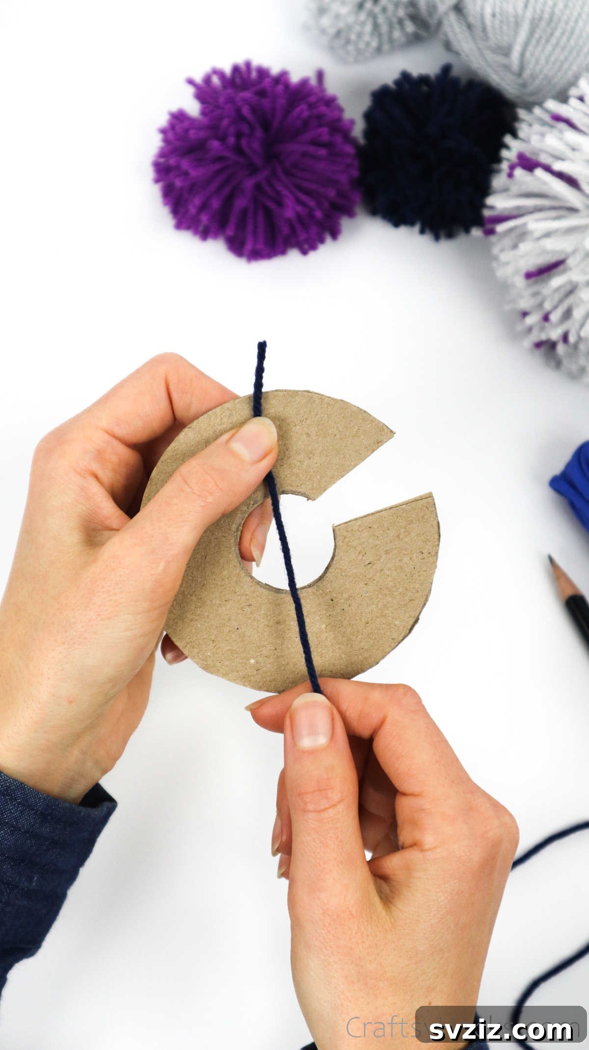 Beginning to wrap yarn around the cardboard disks